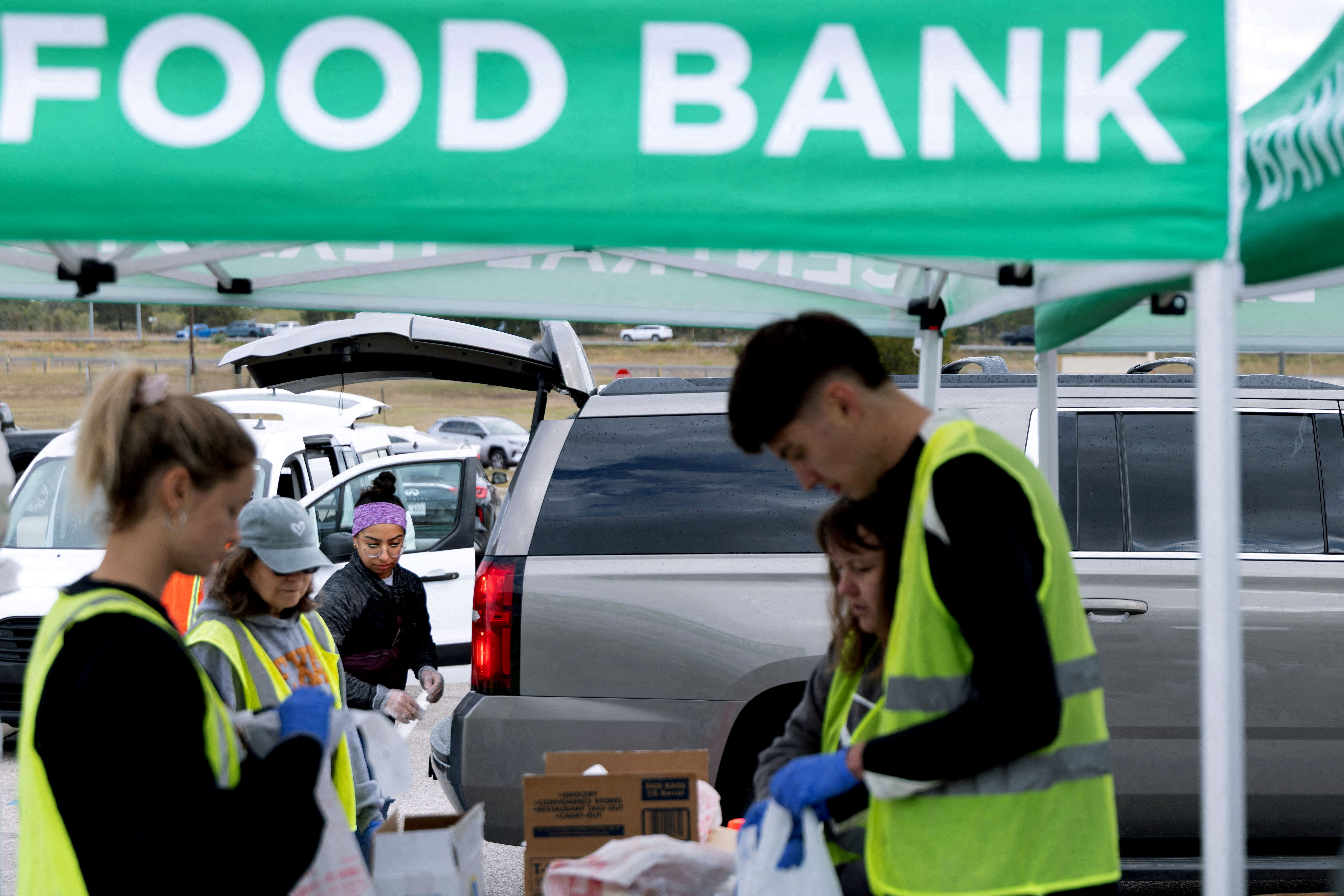 FILE PHOTO: Volunteers place food items in vehicles during a mobile food distribution at Cedar Creek High School, as nearly 42 million Americans face a potential lapse in Supplemental Nutrition Assistance Program (SNAP) benefits, known as food stamps, due to the second-longest U.S. government shutdown, in Cedar Creek, Texas, U.S., November 1, 2025. REUTERS/Kaylee Greenlee/File Photo