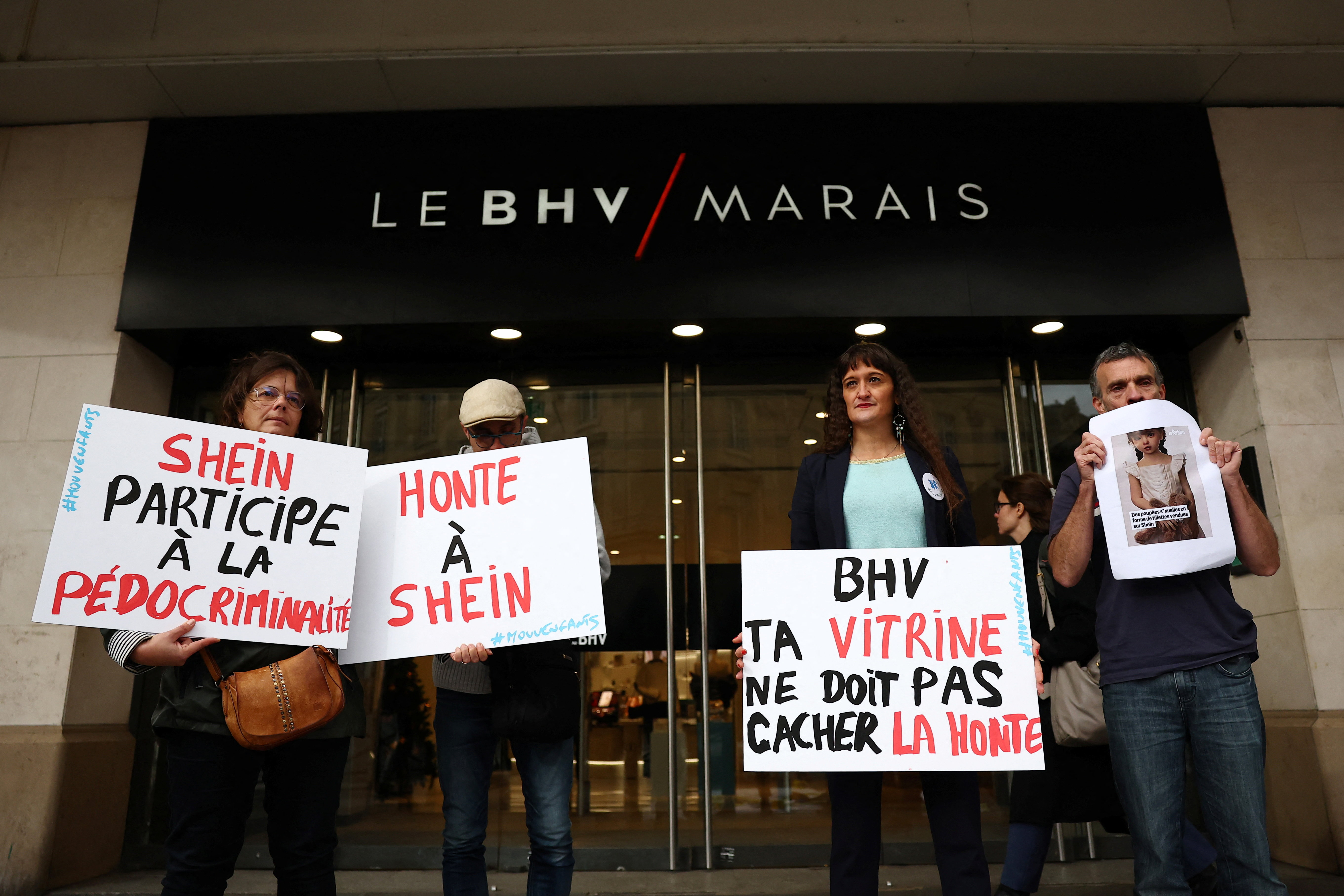 People protest against the sale of child-like sex dolls by Chinese fast-fashion retailer Shein during a demonstration in front of the Bazar de l'Hotel de Ville, Le BHV Marais department store, ahead of the opening of Shein's fast fashion first permanent shop in Paris, France, November 3, 2025. The slogans on placards read "Shame on Shein!", "Shein is complicit in child pornography" and "BHV, your shop window shouldn't hide this shame". [Abdul Saboor/Reuters]