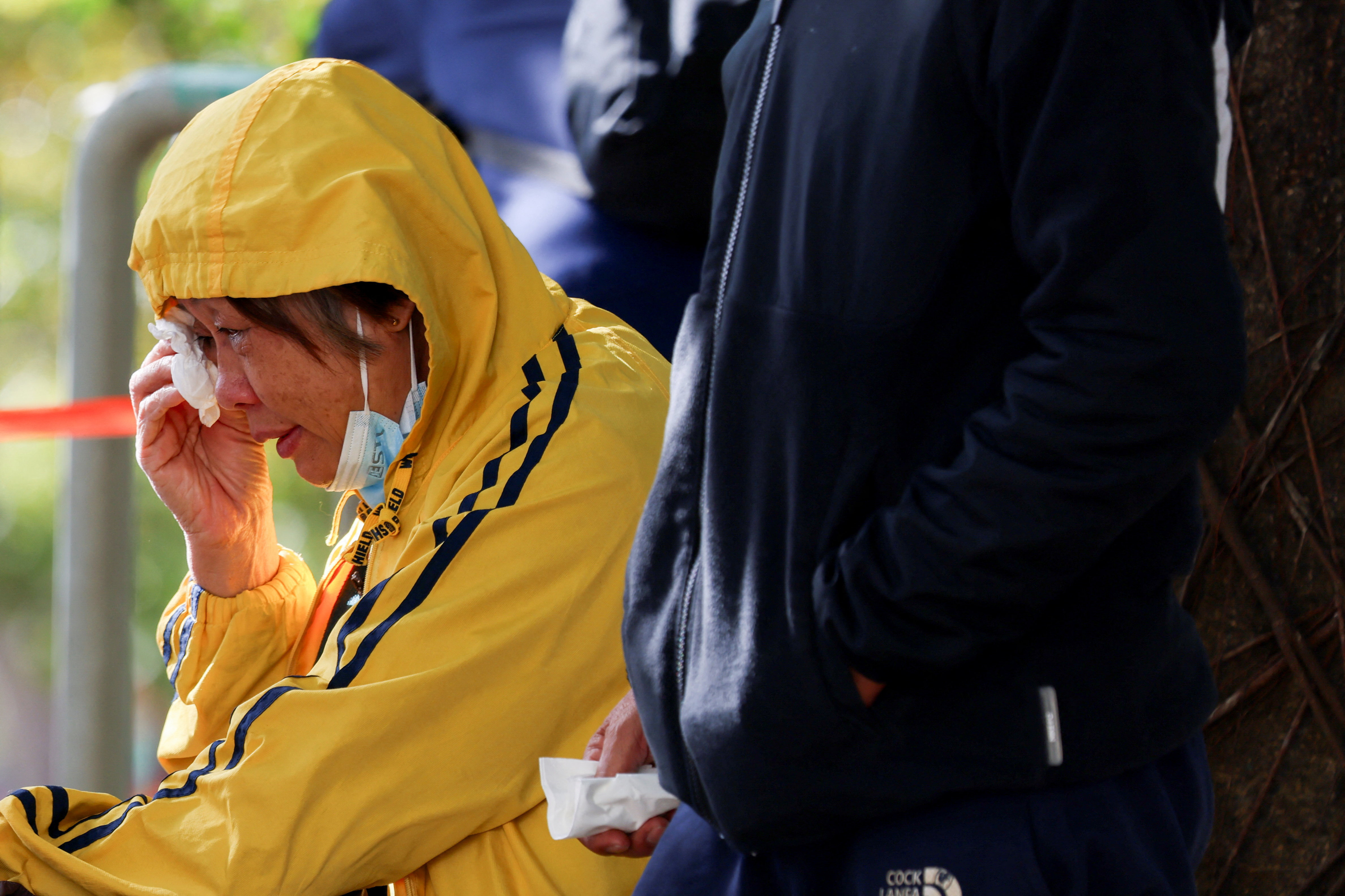 A woman reacts outside the Kwong Fuk Community Hall where relatives identify family members from photos, following the Wang Fuk Court housing complex fire, in Tai Po, Hong Kong, China, November 28, 2025. REUTERS/Tyrone Siu