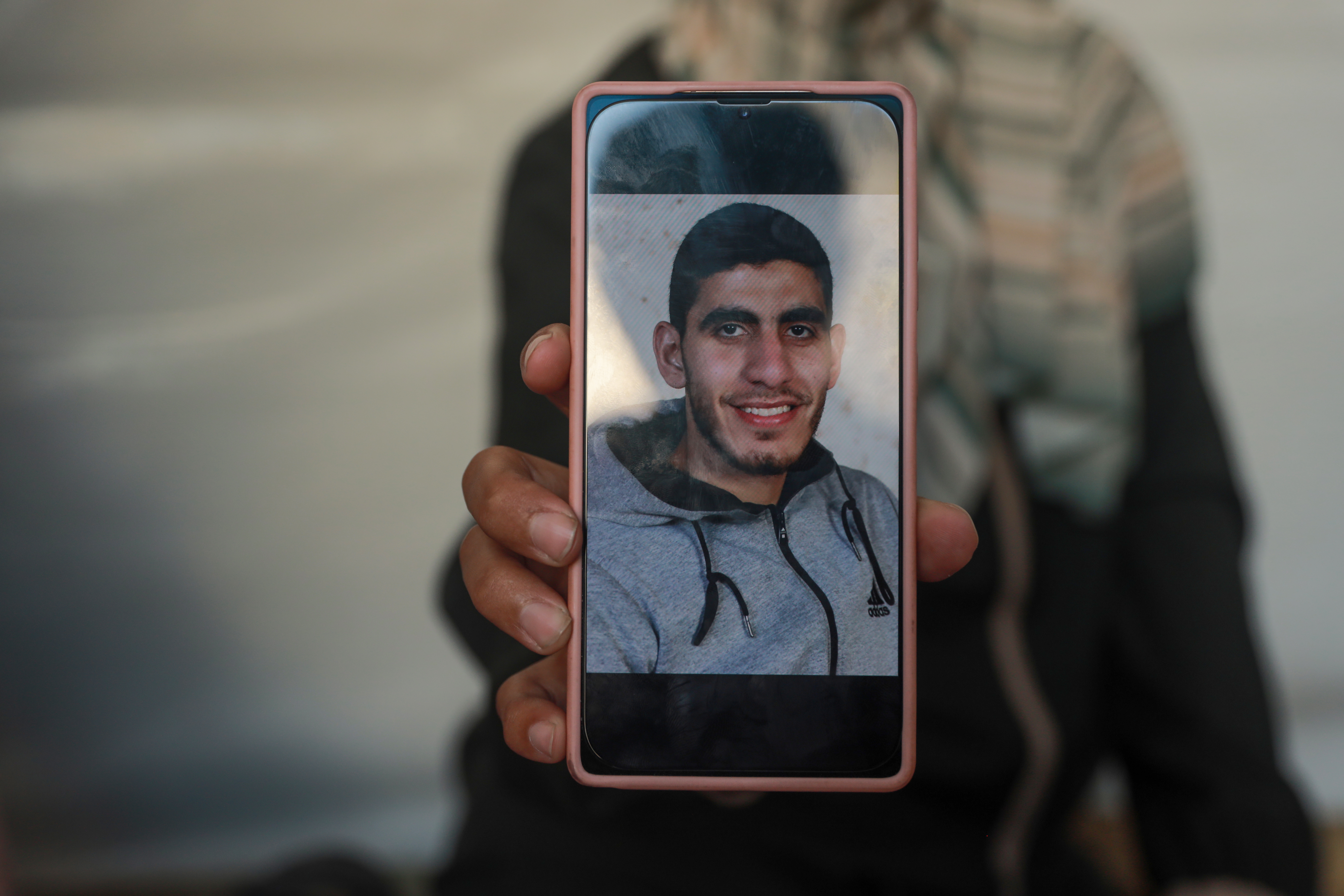 A mobile phone shows an image of Israa's brother Diaa