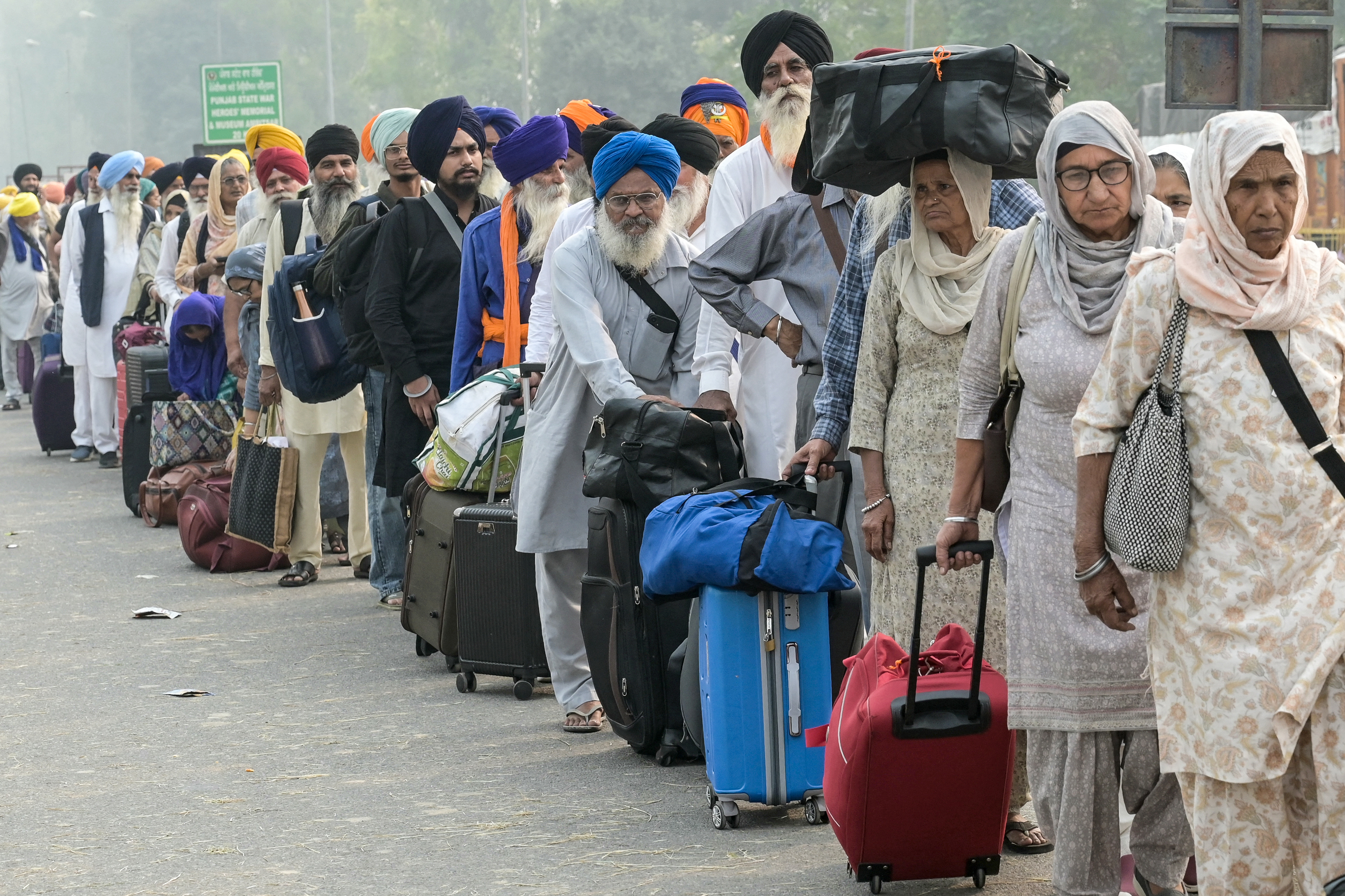 Indian Sikh pilgrims wave as they head to Pakistan through the India-Pakistan Wagah border