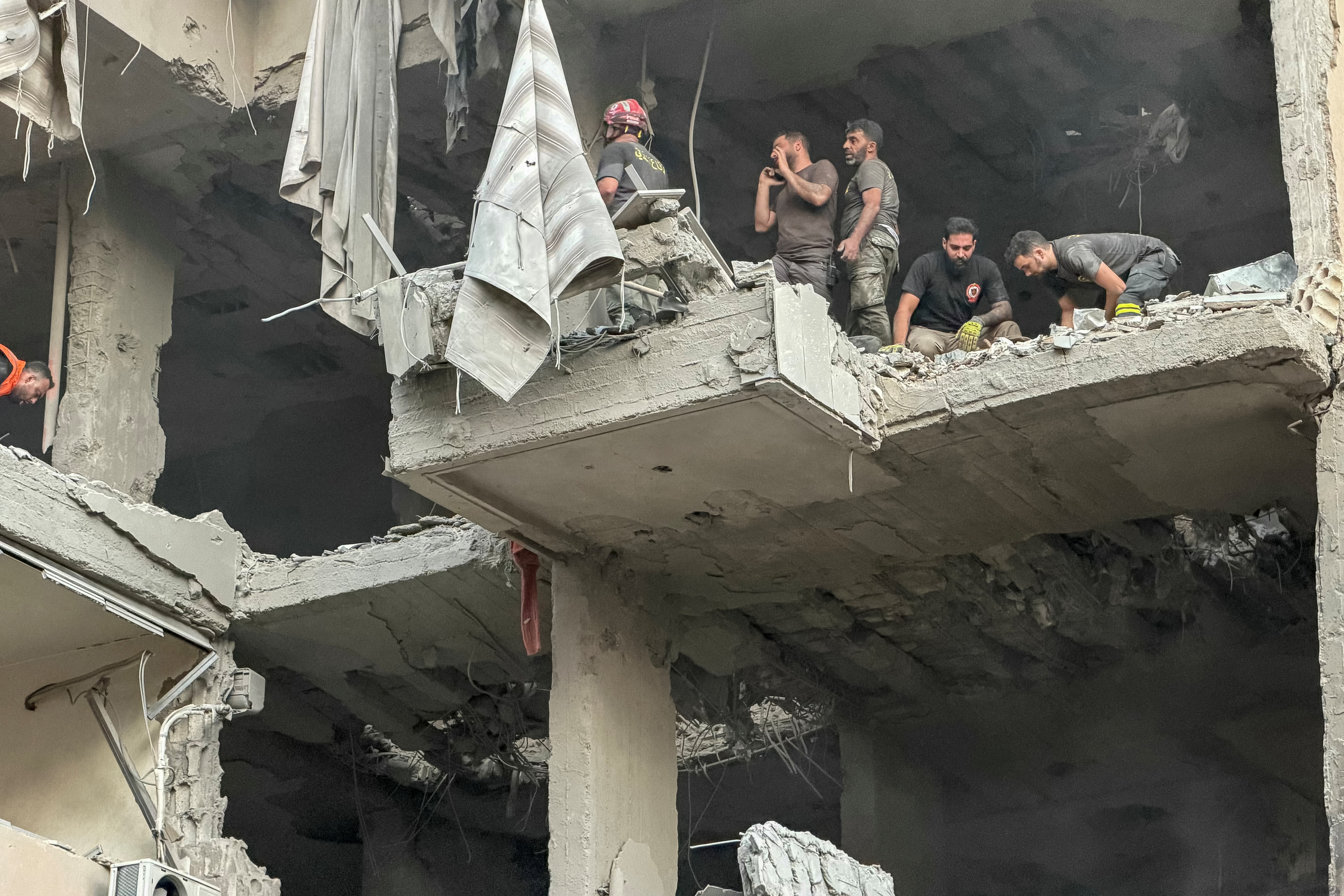 Rescuers search for survivors at the site of an Israeli air attack on a residential building.