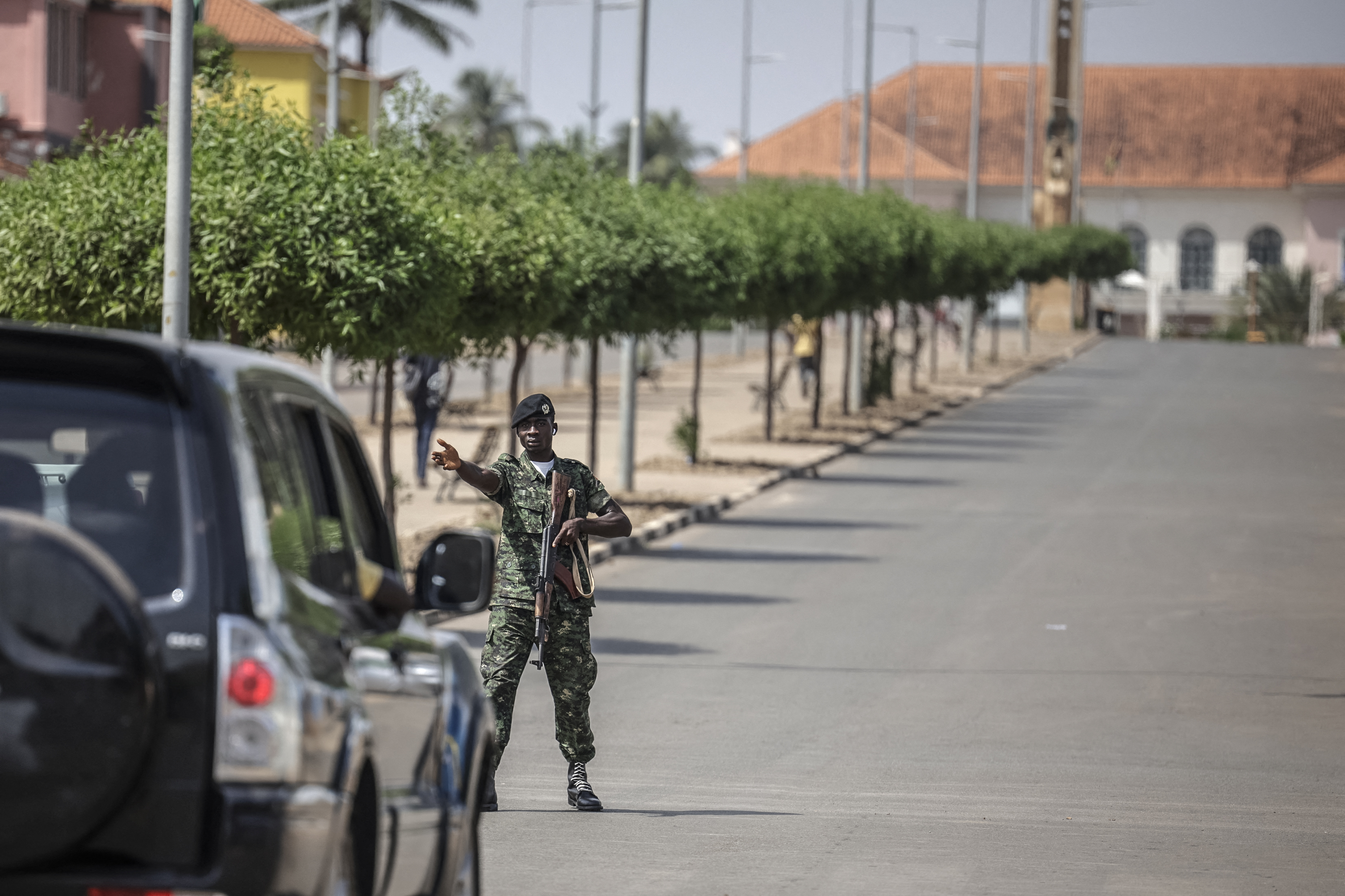 A soldier stops a car near the scene of gunfire in Guinea-Bissau's capital