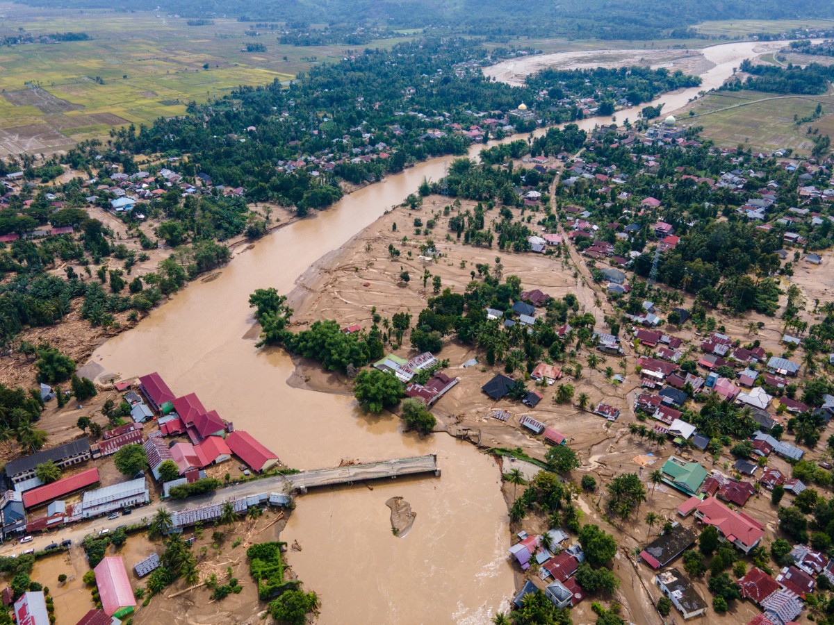 This aerial picture shows a bridge damaged by flash floods on a main road connecting Aceh and North Sumatra in Meureudu, Pidie Jaya district Indonesia's Aceh province on November 28, 2025. (Photo by CHAIDEER MAHYUDDIN / AFP/Chaideer MAHYUDDIN / AFP)