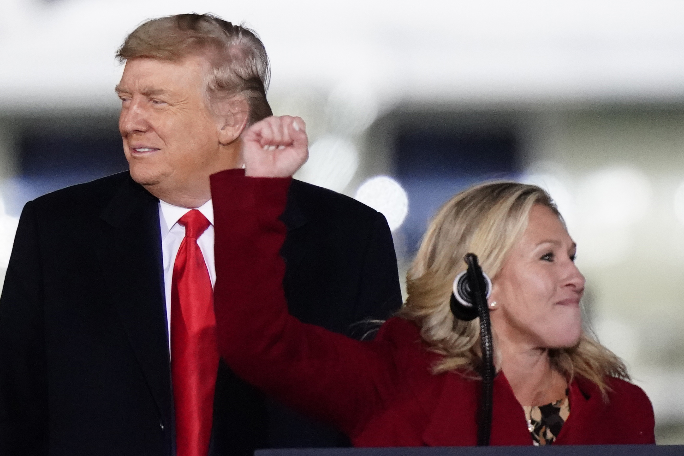 Rep. Marjorie Taylor Greene, R-Ga., speaks as President Donald Trump listens at a campaign rally in support of Senate candidates Sen. Kelly Loeffler, R-Ga., and David Perdue in Dalton, Ga., Monday, Jan. 4, 2021. (AP Photo/Brynn Anderson)