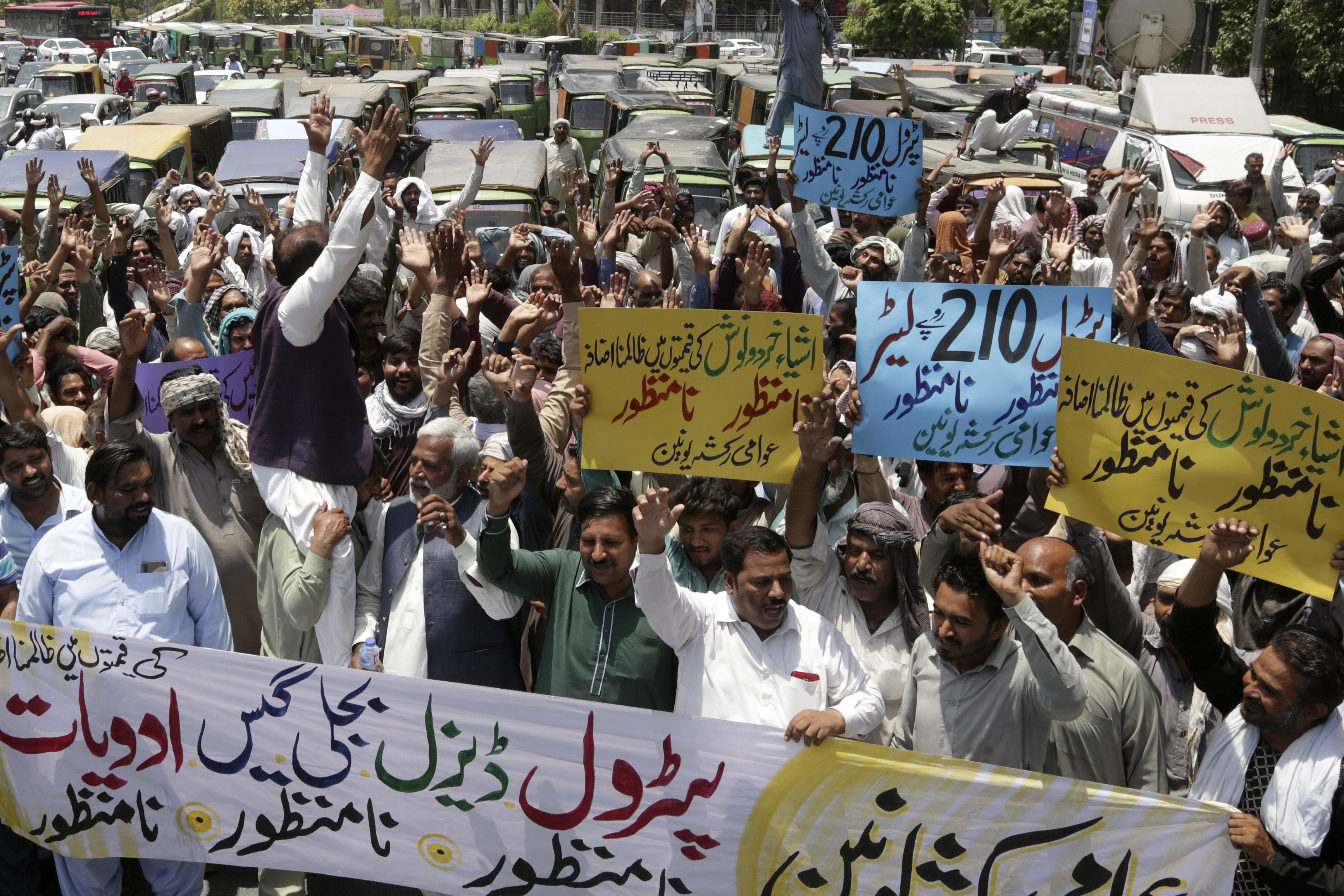 Pakistani rickshaw drivers chant slogans during a protest against the recent increasing in petrol prices, Friday, June 3, 2022. Pakistani government massively increased in petrol to revive IMF program draws. (AP Photo/K.M. Chaudary)