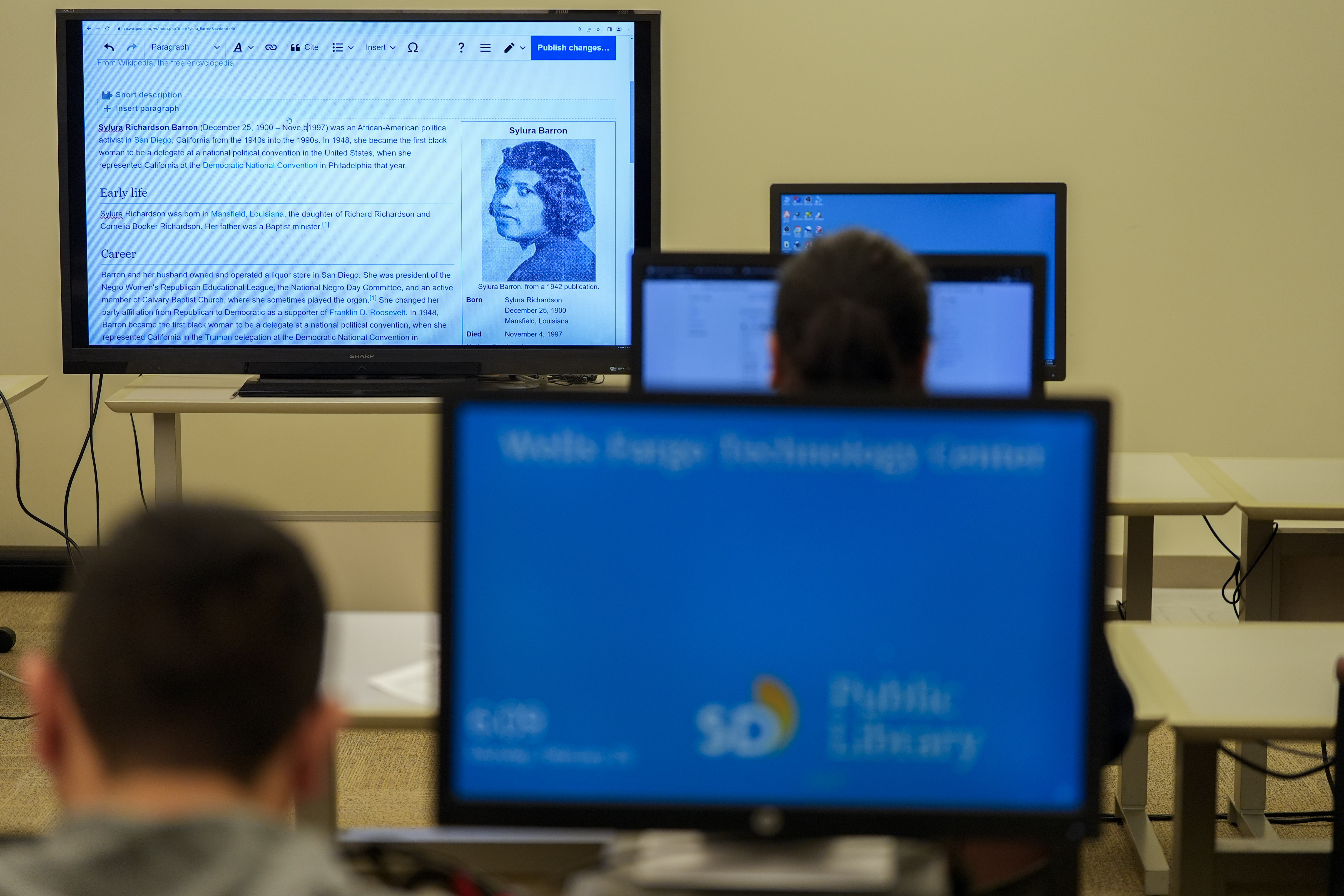 Pages on Wikipedia are displayed on screens as people edit.