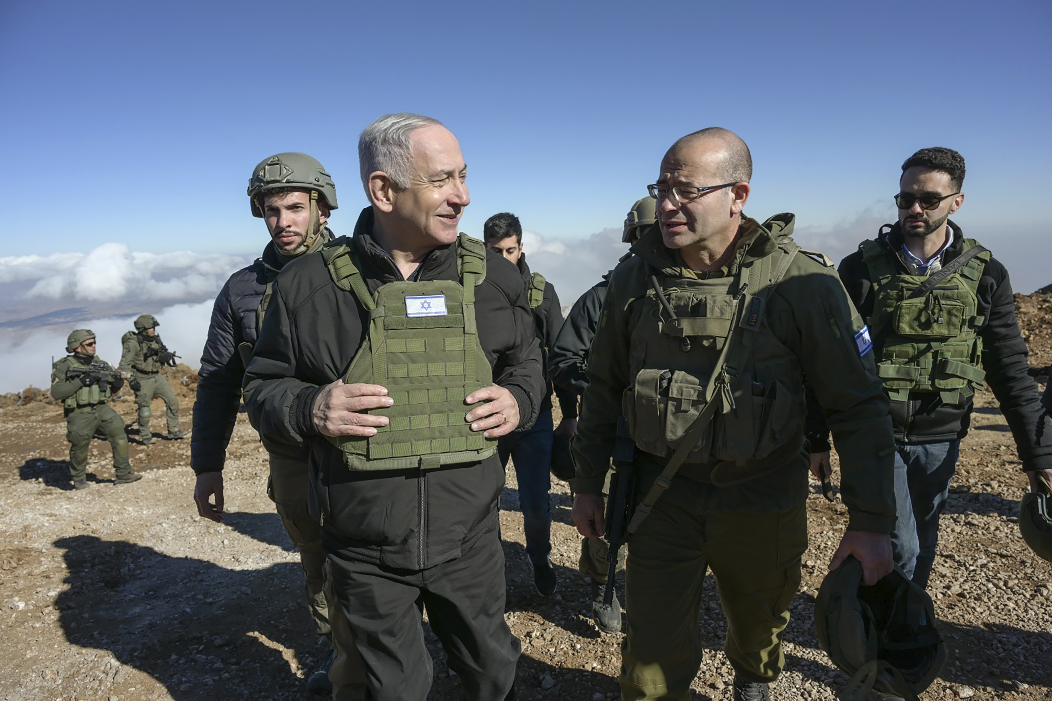 Israel's Prime Minister Benjamin Netanyahu, left, visits Israeli forces in a buffer zone inside Syria