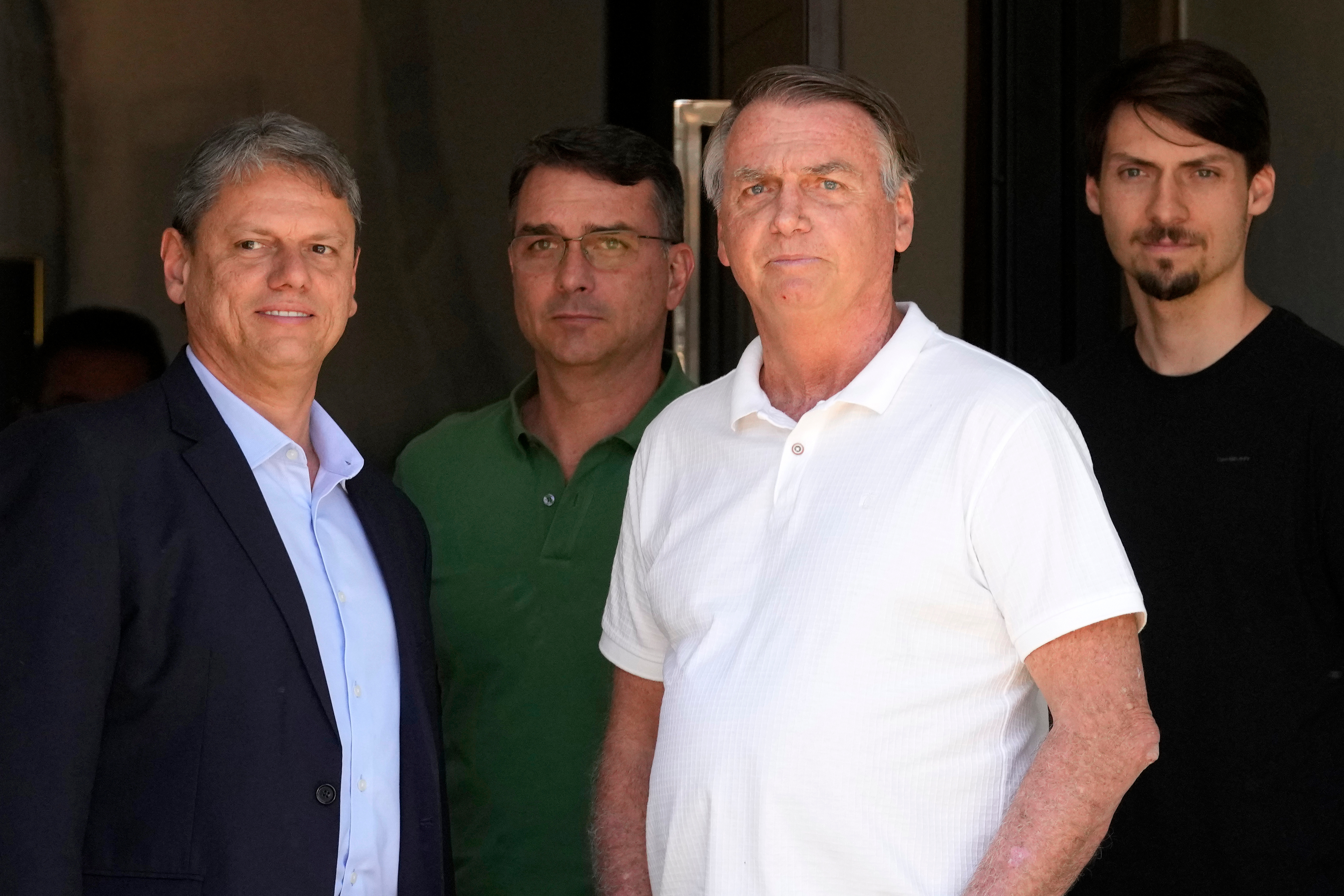 Bolsonaro and his children stand outside his house.