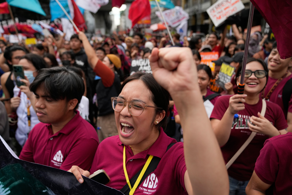 Protesters shout and raise their fists during a demonstration.