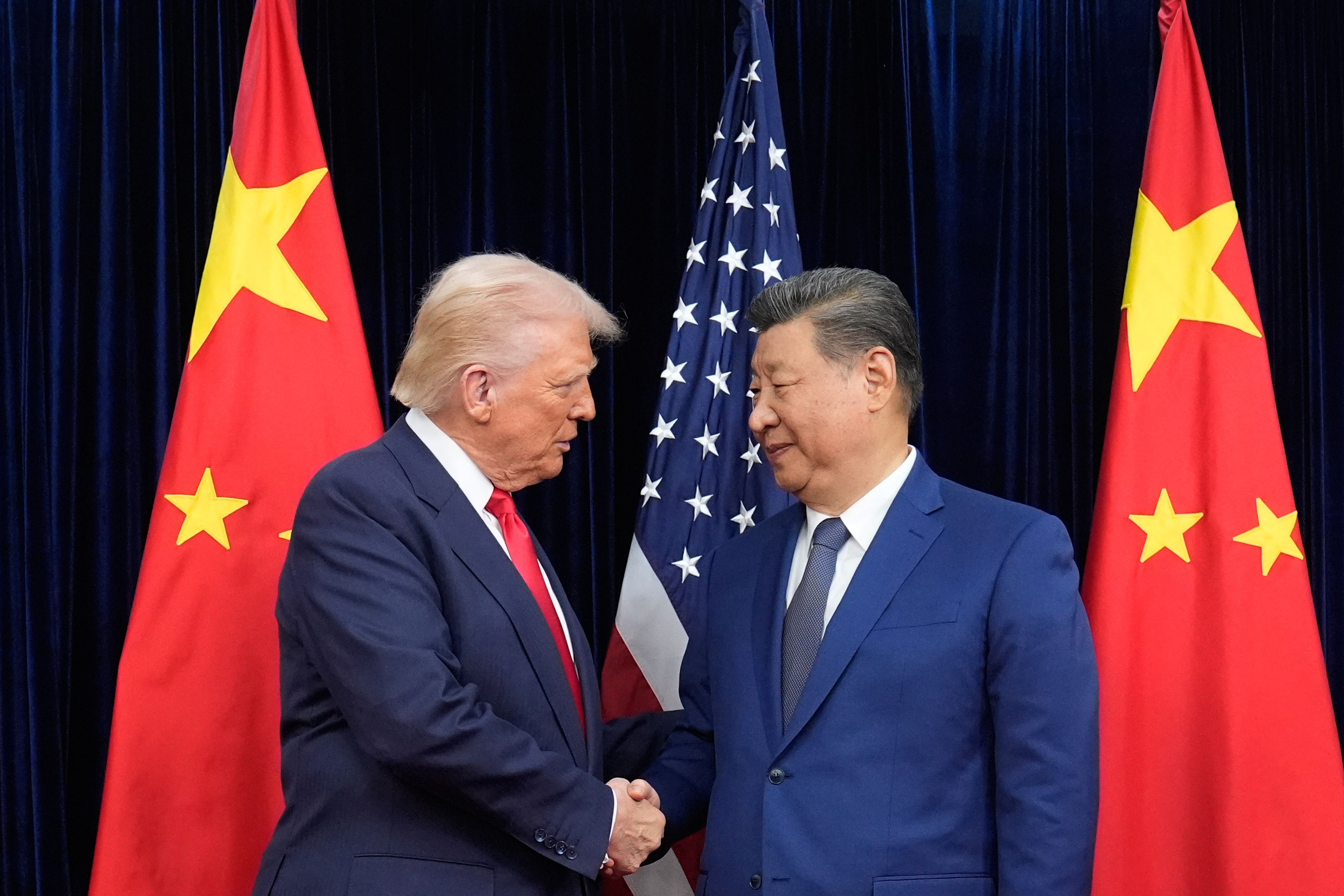 US President Donald Trump, left, and Chinese President Xi Jinping, right, shake hands before their meeting at Gimhae International Airport in Busan, South Korea on October 30, 2025.
