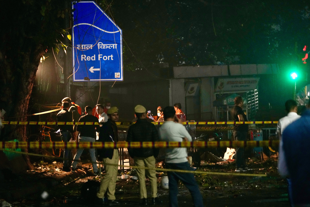 Security officers inspect the site of a car explosion near the Red Fort in Delhi