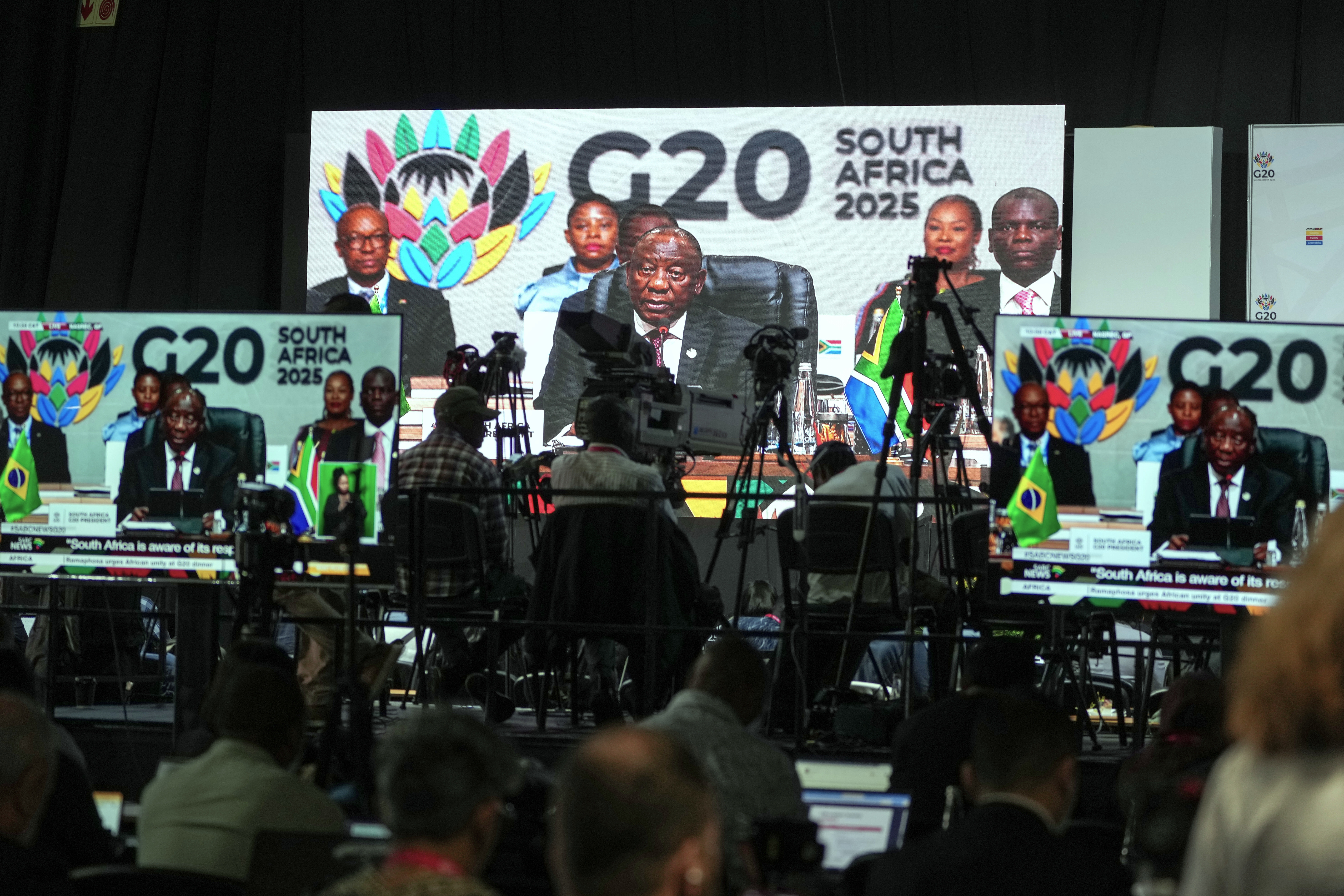 Members of the media watch on screens as South African President Cyril Ramaphosa addresses the opening session of the G20 leaders' summit, in Johannesburg, South Africa