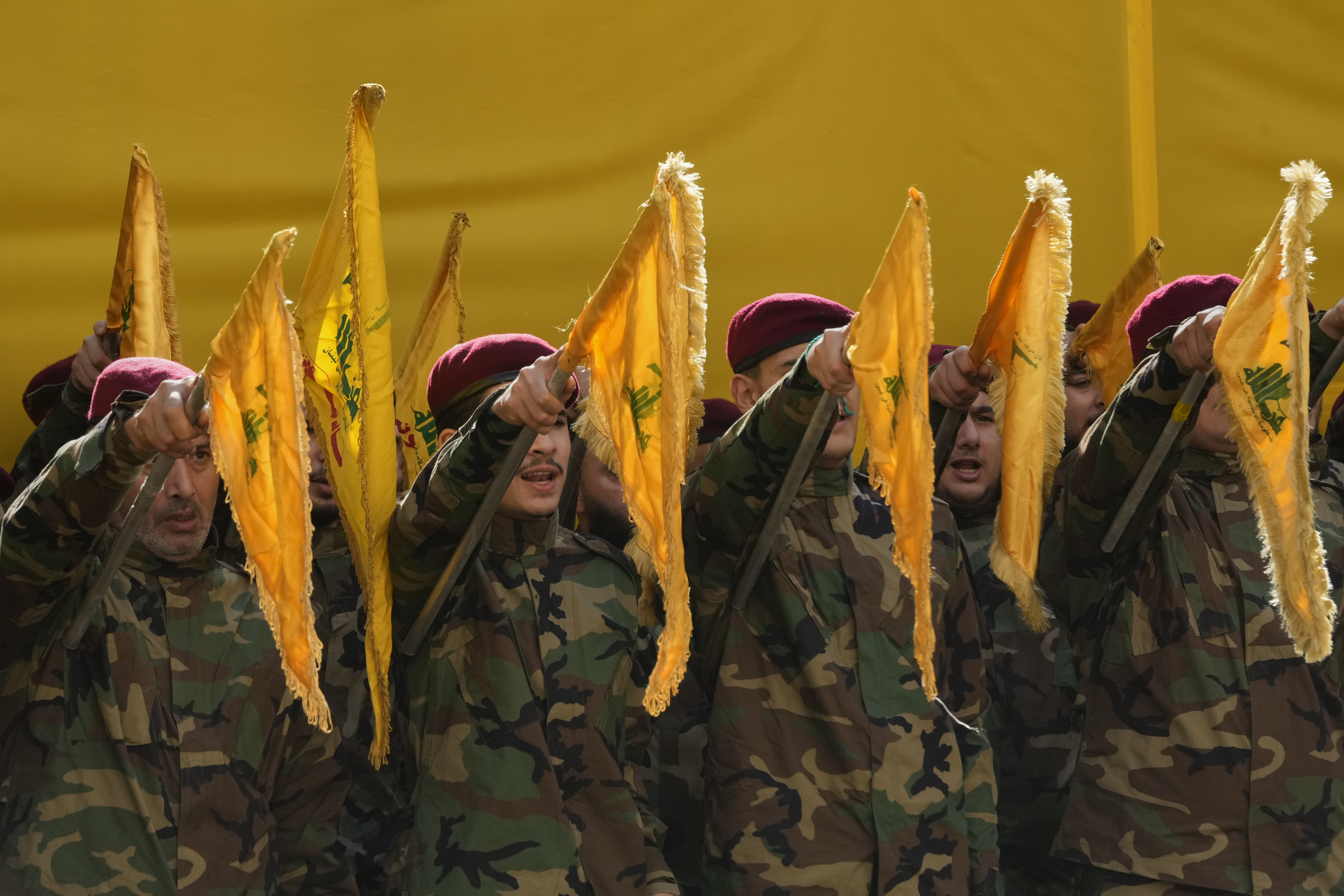 Hezbollah fighters raise their group's flags and chant slogans.