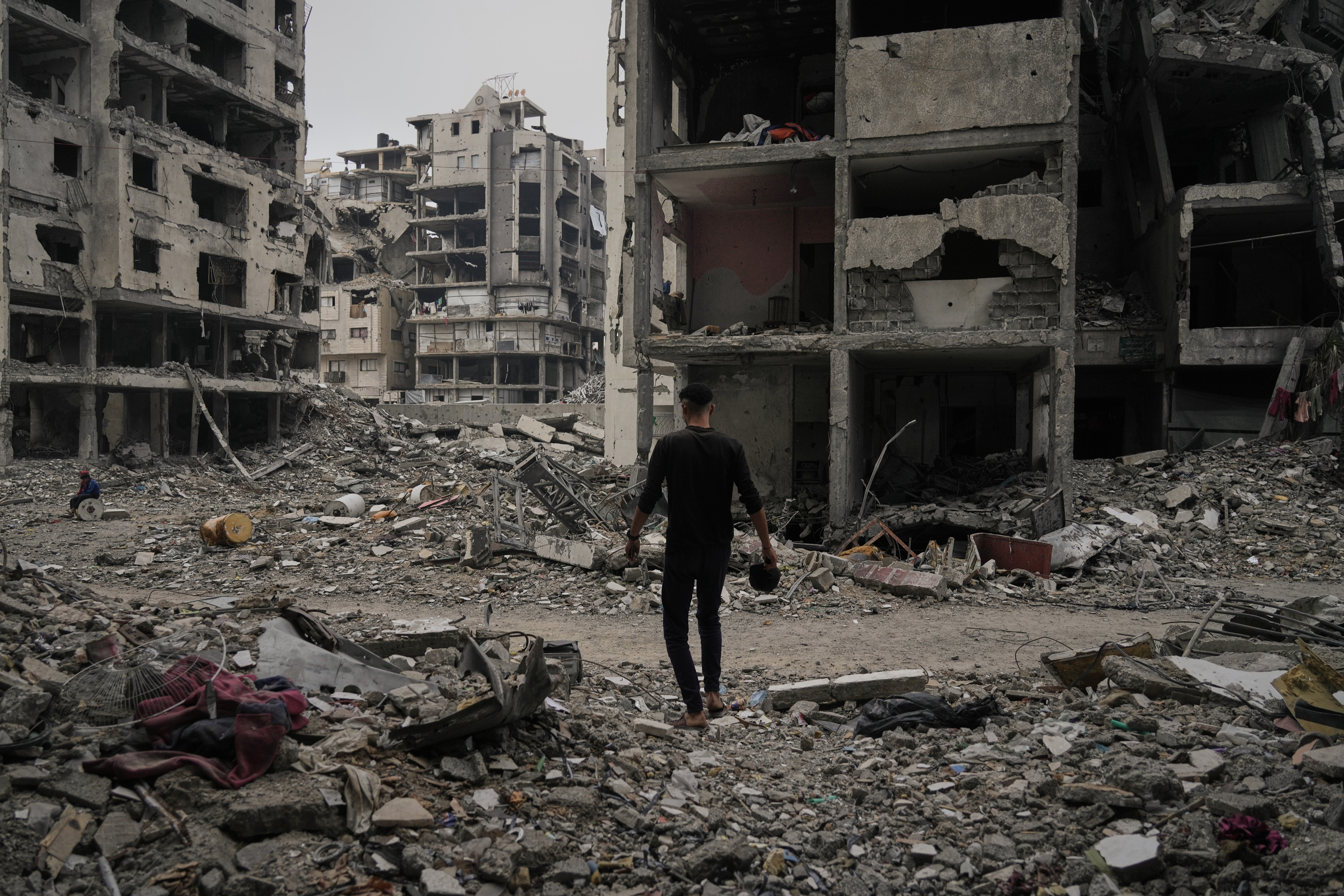 A Palestinian man walks among the ruins of destroyed buildings in Gaza City Monday, Nov. 24, 2025. (AP Photo/Jehad Alshrafi)