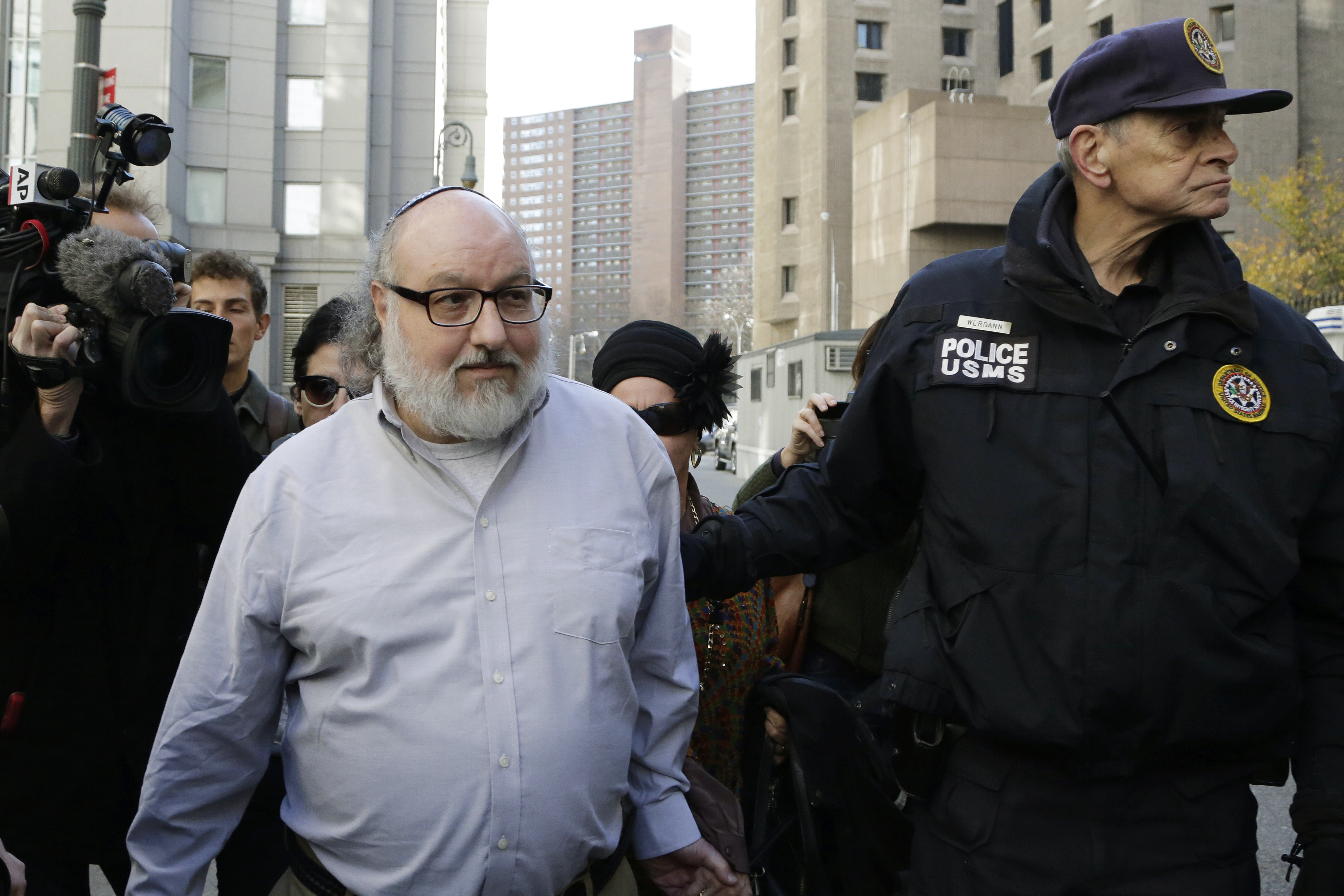Convicted spy Jonathan Pollard, left, is escorted by a Federal Marshall as he leaves the federal courthouse in New York, Friday, Nov. 20, 2015. Within hours of his release, Pollard's attorneys began a court challenge to terms of his parole. He served 30 years for selling intelligence secrets to Israel. (AP Photo/Mark Lennihan)