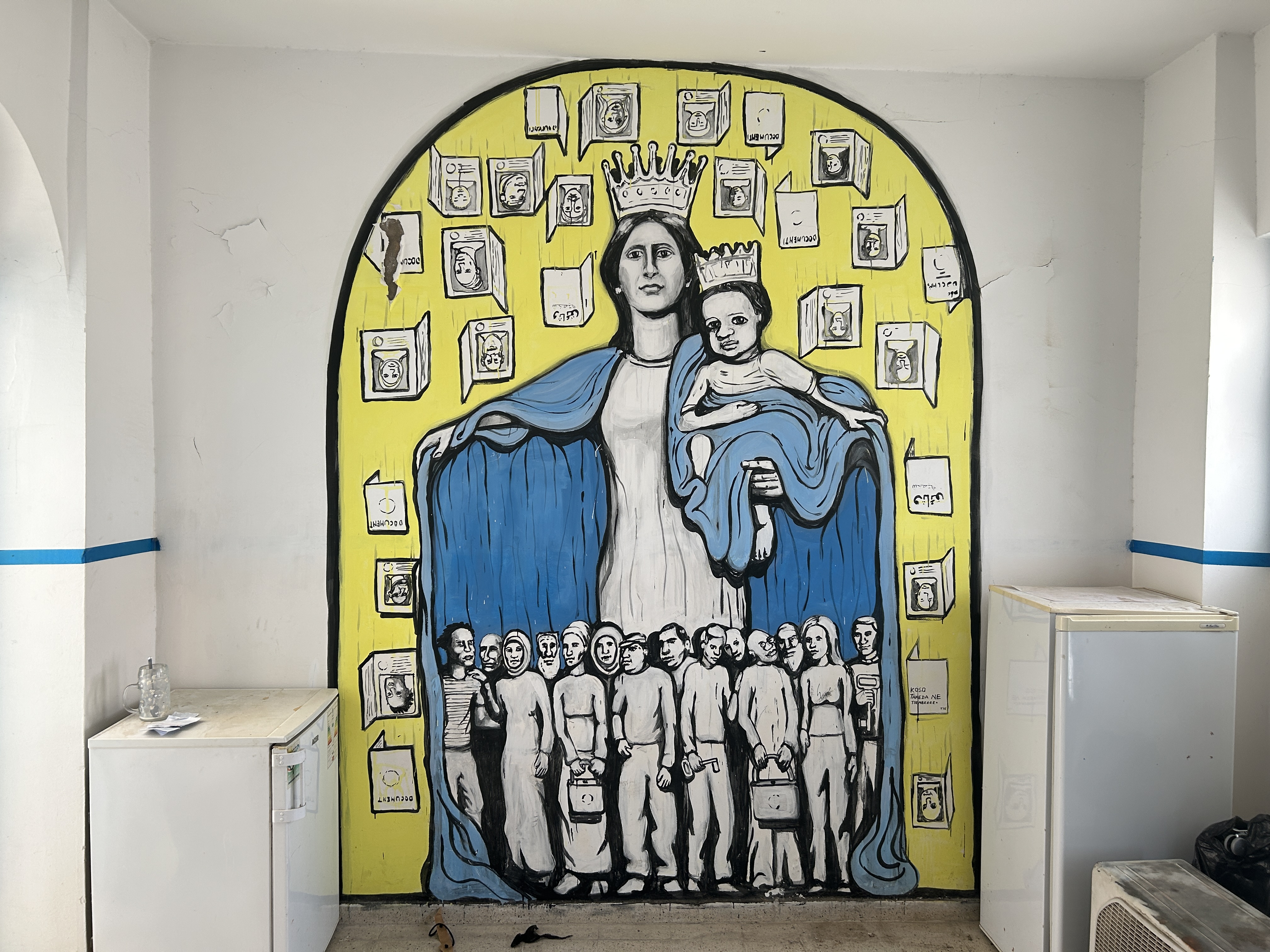 A mural of the Virgin Mary with migrants and passports around her