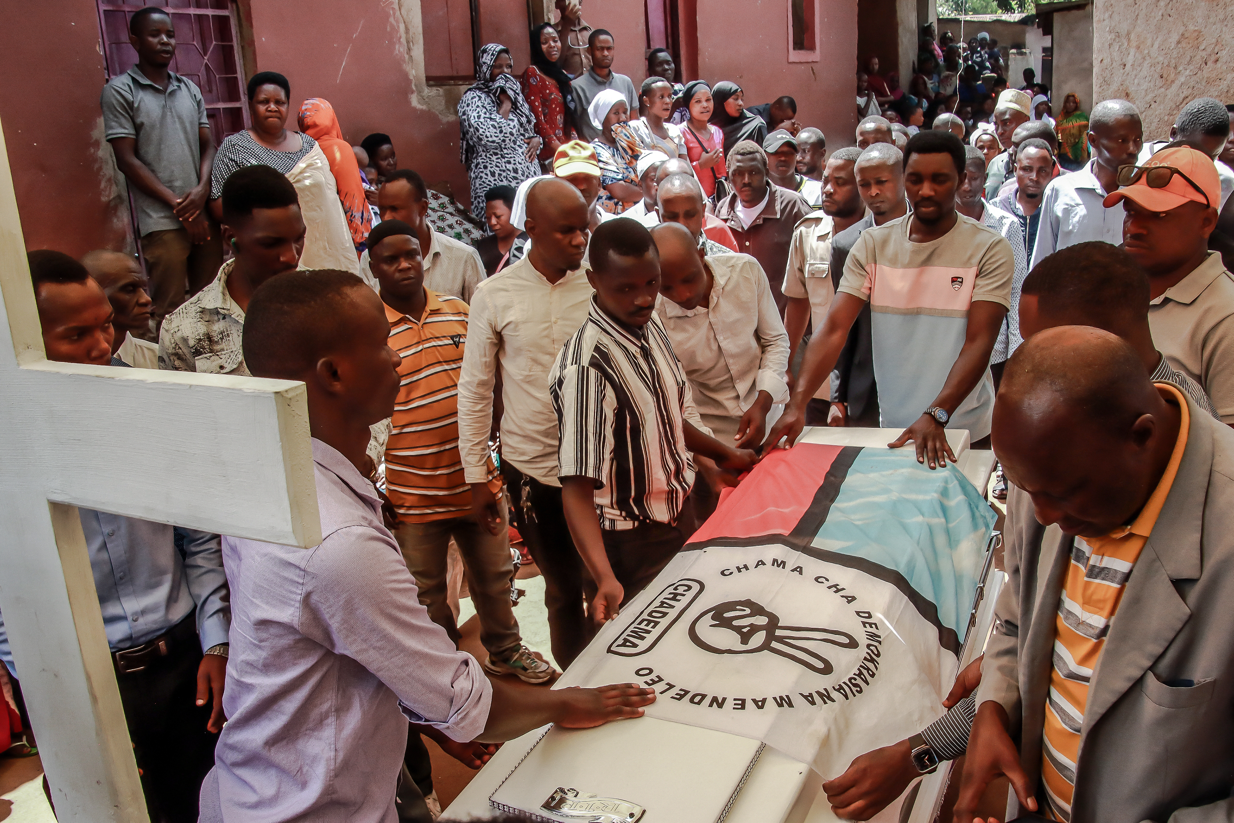 Mourners place a party flag on top of the coffin of Michael Christian, Chairman of Youth for Nyamagana District of Tanzania’s opposition party Chadema, who was killed amid unrest following Tanzania’s presidential election, in Mwanza on November 6, 2025.