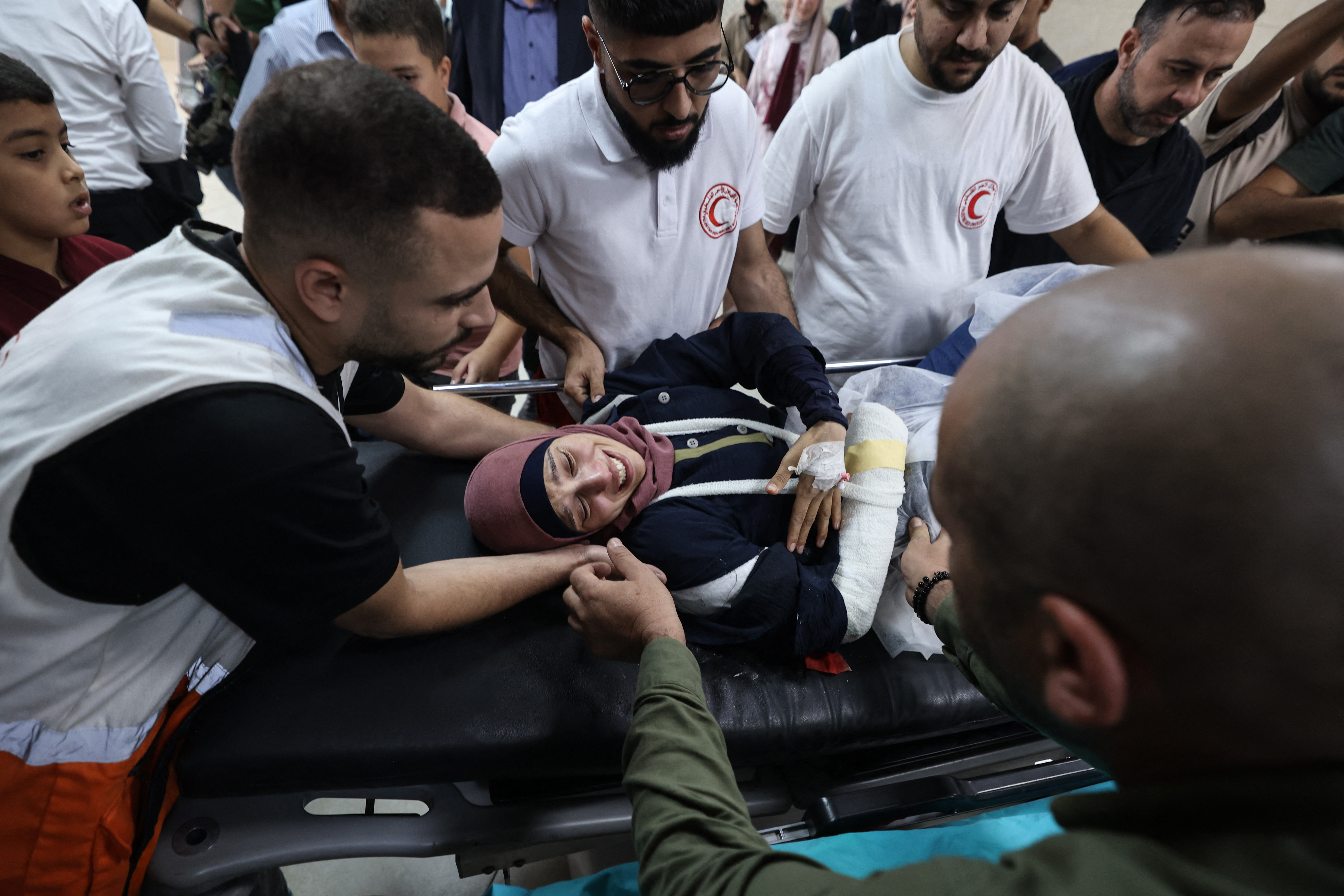 TOPSHOT - Palestinian photographer Raneen Sawafta reacts as she is carried on a stretcher at Rafidia Hospital in Nablus after reportedly being injured by Israeli settlers while covering the olive harvest in the Palestinian village of Baita, in the Israeli-occupied West Bank, on November 8, 2025.