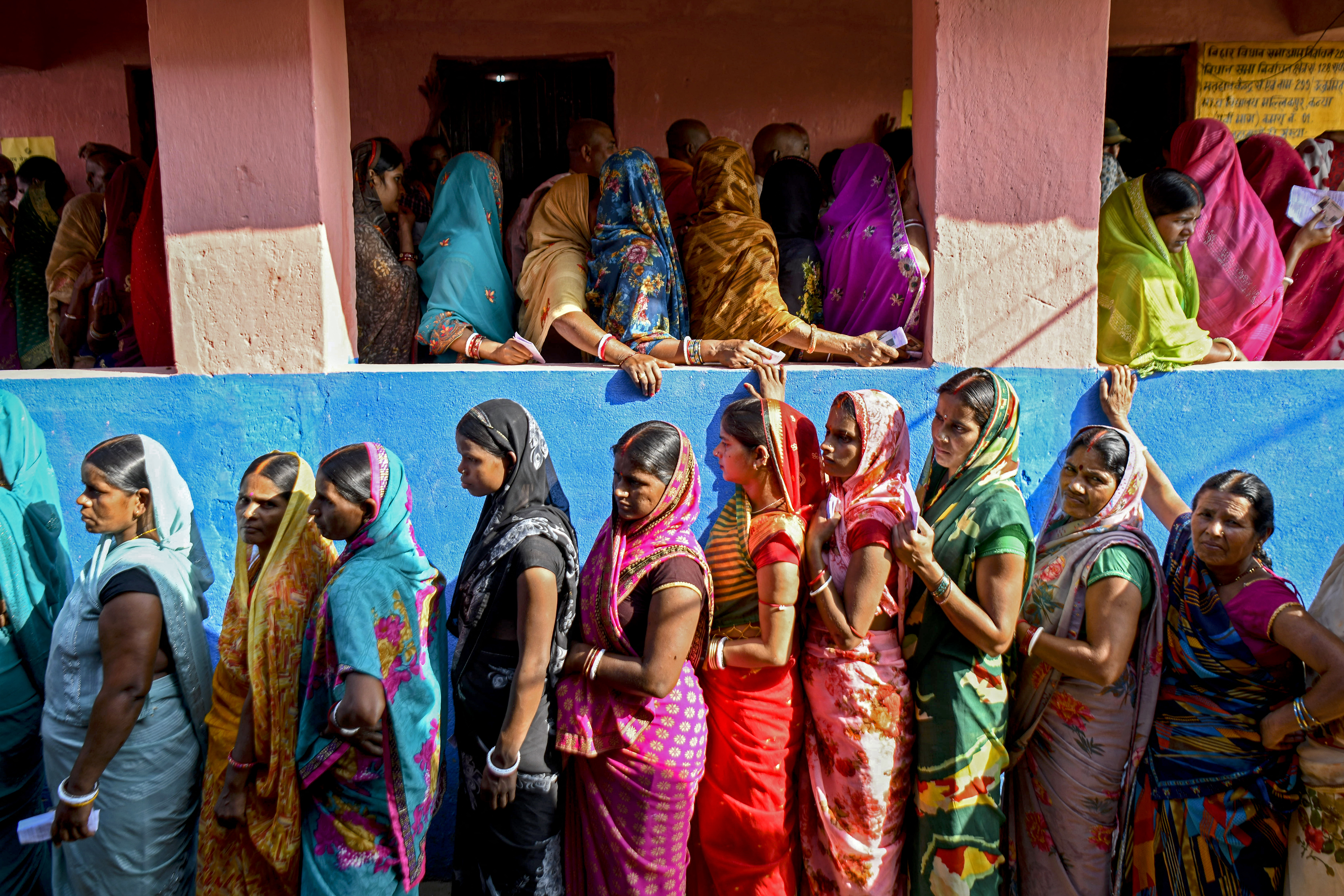 Female voters stand in queues to cast their ballots at a polling station in Bihar on November 6, 2025