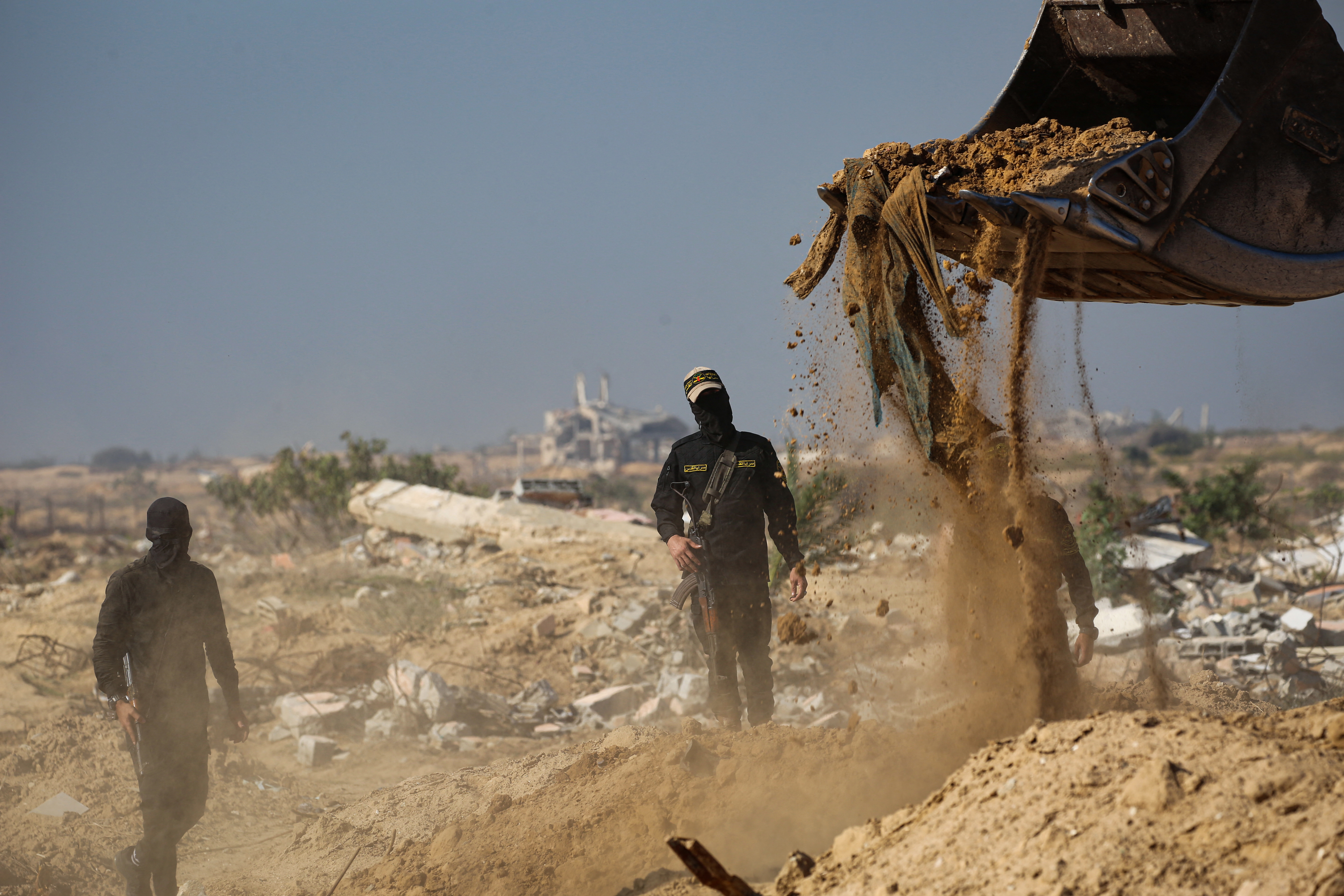 Masked gunmen from the Palestinian Islamic Jihad movement search for bodies in Nuseirat in the central Gaza Strip on November 21, 2025.