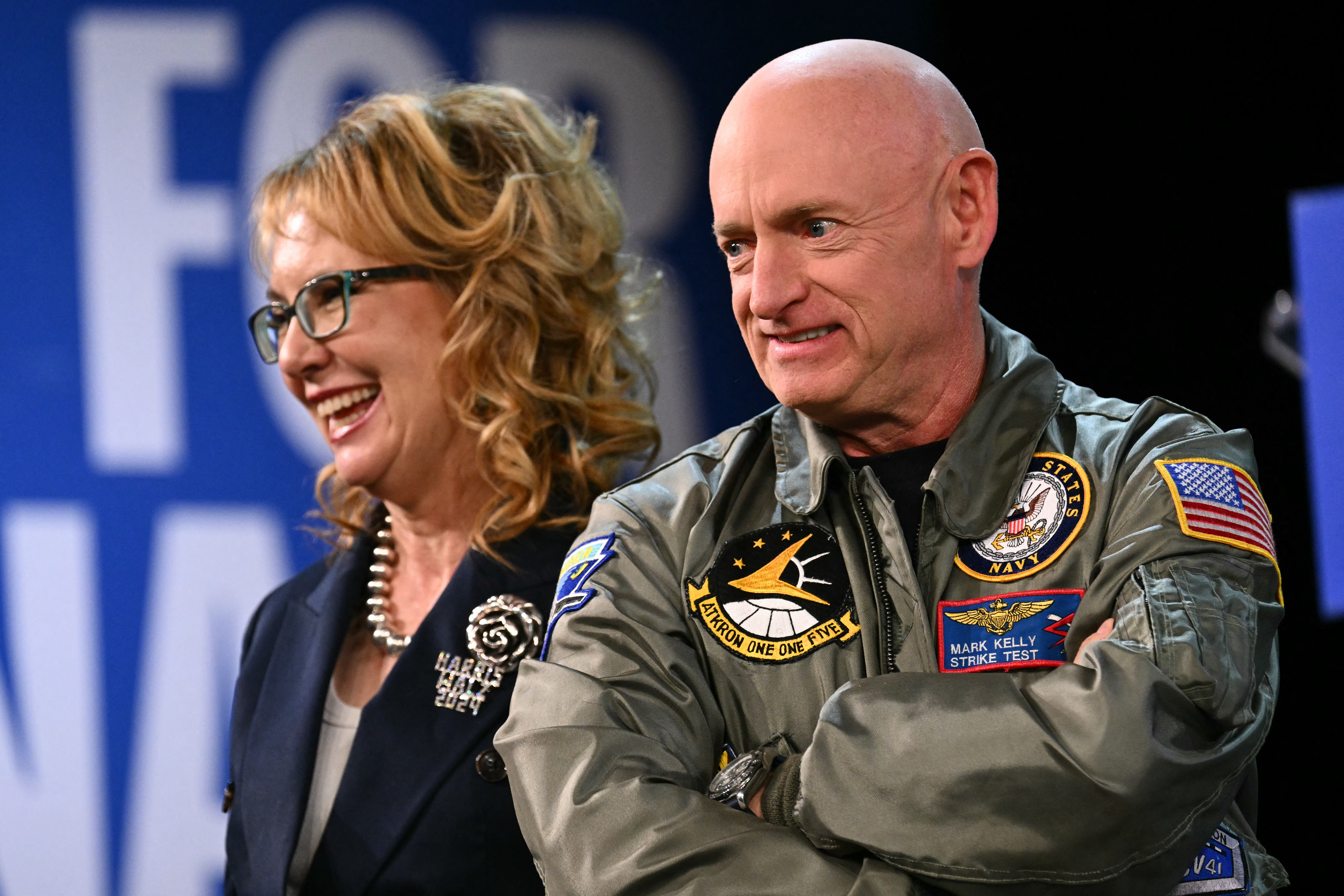 (FILES) Former Congresswoman Gabby Giffords (L) and husband US Senator Mark Kelly, Democrat from Arizona, stand on stage during the Harris-Walz Campaign Election Eve rally and concert at the Celebrity Theater in Phoenix, Arizona, on November 4, 2024.