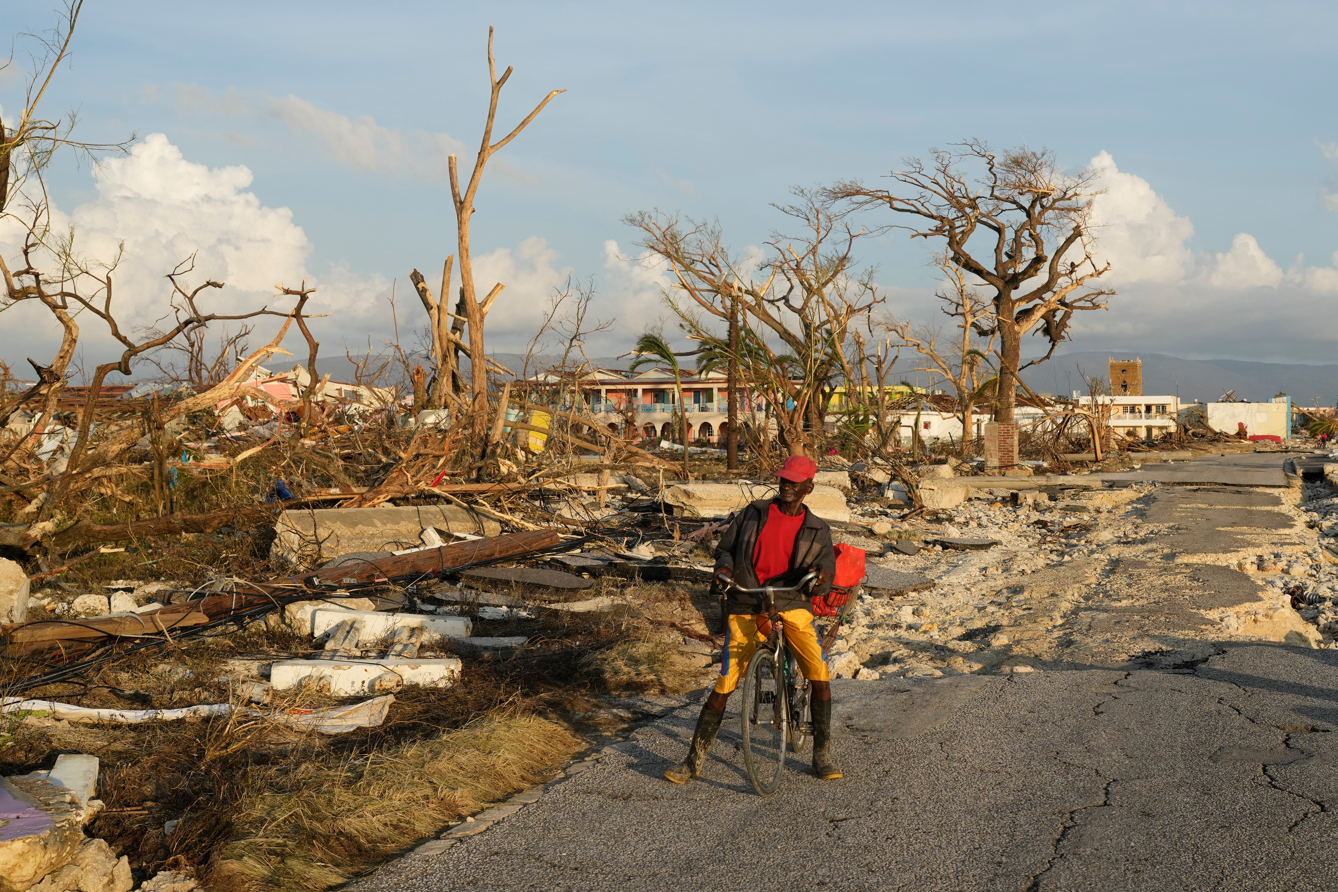 A man rests on a bicycle near destroyed houses in Black River, Jamaica, Thursday, Oct. 30, 2025, in the aftermath of Hurricane Melissa. (AP Photo/Matias Delacroix)