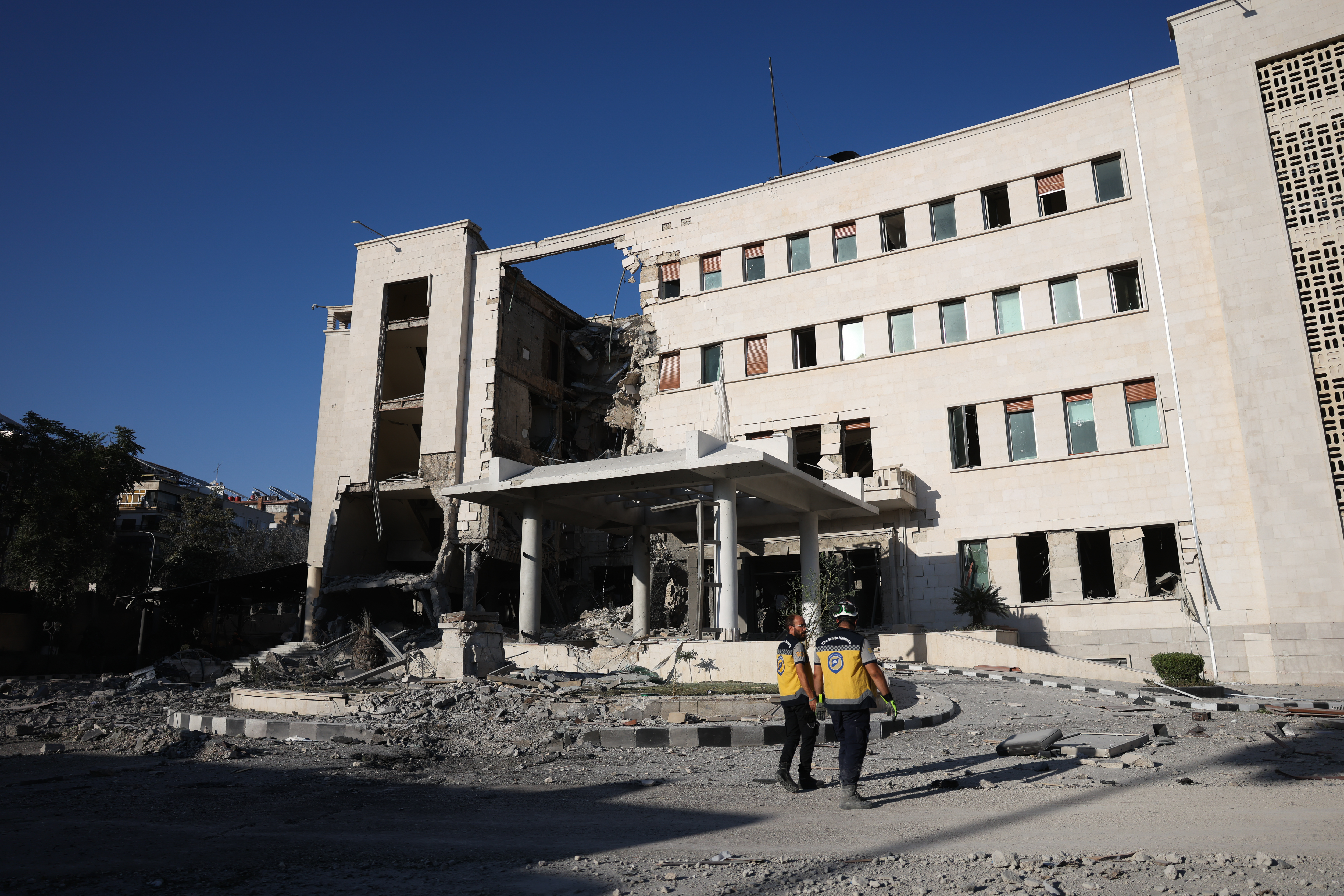 DAMASCUS, SYRIA - JULY 16: Members of Syria's civil defense work amid the aftermath of an Israeli airstrike on Syria's defence ministry headquarters on July 16, 2025 in Damascus, Syria. A spokesperson from the Israeli Defense Forces (IDF) confirmed Wednesday that Israeli airstrikes have targeted the headquarters of Syria's defence ministry and a site near the presidential palace in Damascus. The strikes come amid an escalation in conflict between Syrian government forces and Druze militia in the southern Syrian city of Sweida, or Suwayda. Israel has previously vowed to protect the Druze in Syria, due to the deep brotherly alliance with our Druze citizens in Israel, and their familial and historical ties to the Druze in Syria, according to Israeli Prime Minister Benjamin Netanyahu's office. (Photo by Ali Haj Suleiman/Getty Images)