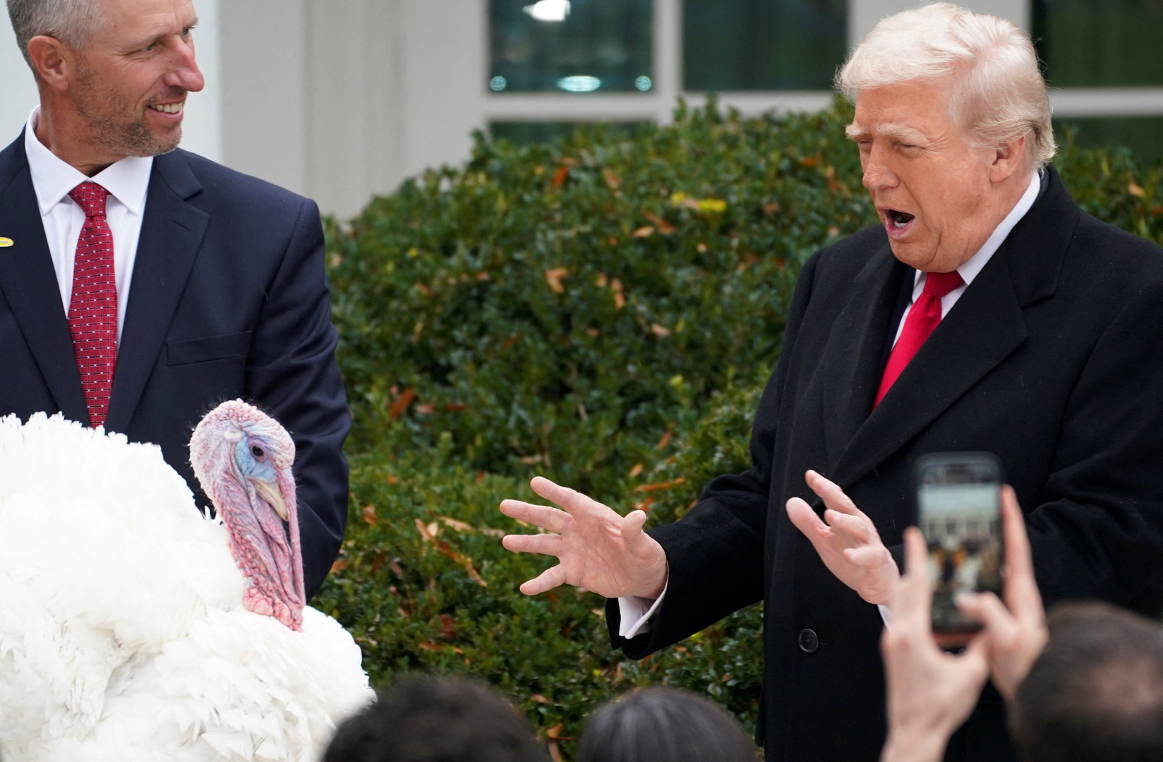 US President Donald Trump reacts next to Gobble, one of two turkeys ceremonially pardoned for Thanksgiving, in the Rose Garden at the White House in Washington, DC, US on Nov. 25, 2025. [Jonathan Ernst/Reuters]