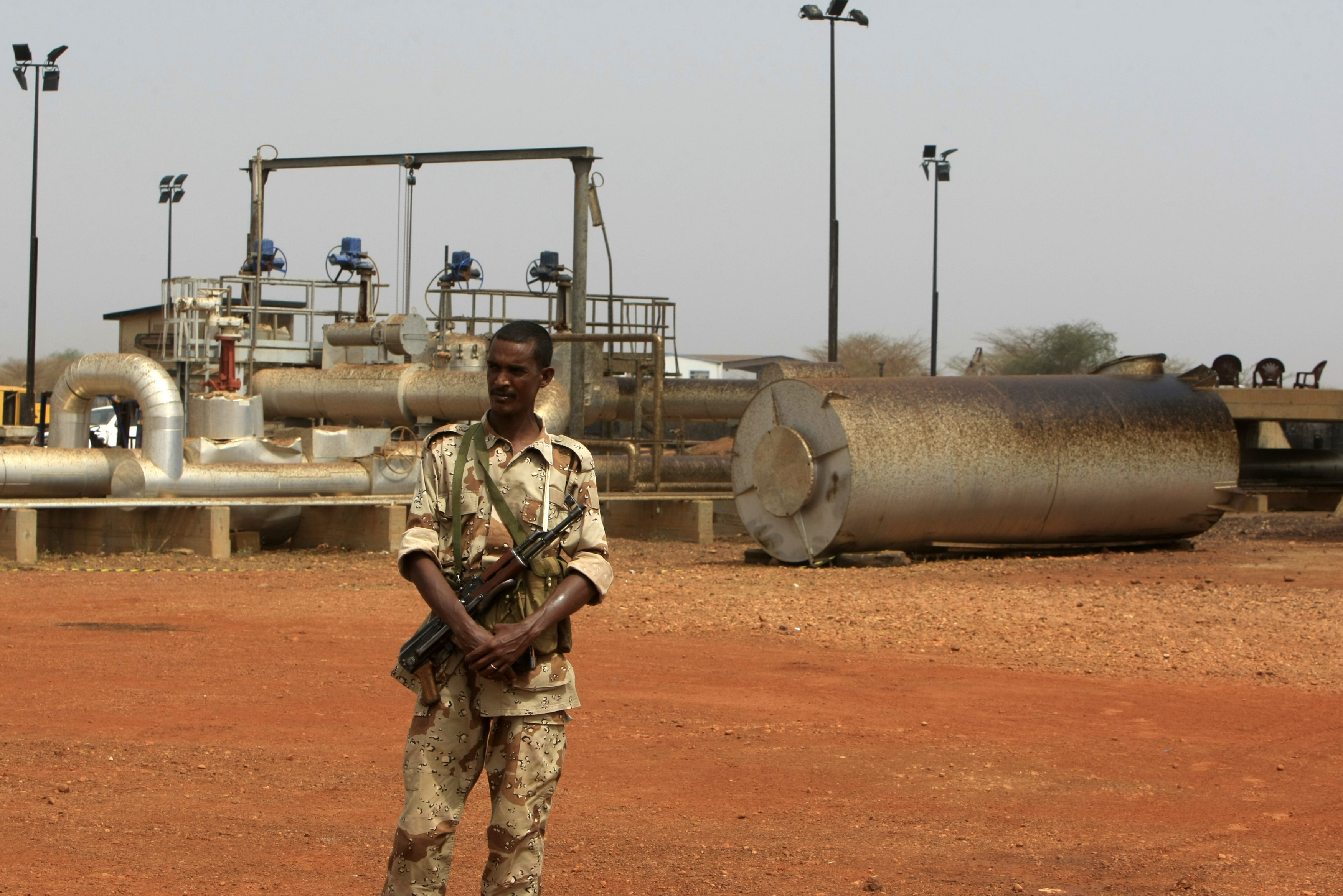 A member of the military stands guard near pump stations before a ceremony in which oil operations at Heglig oilfield will resume in Heglig