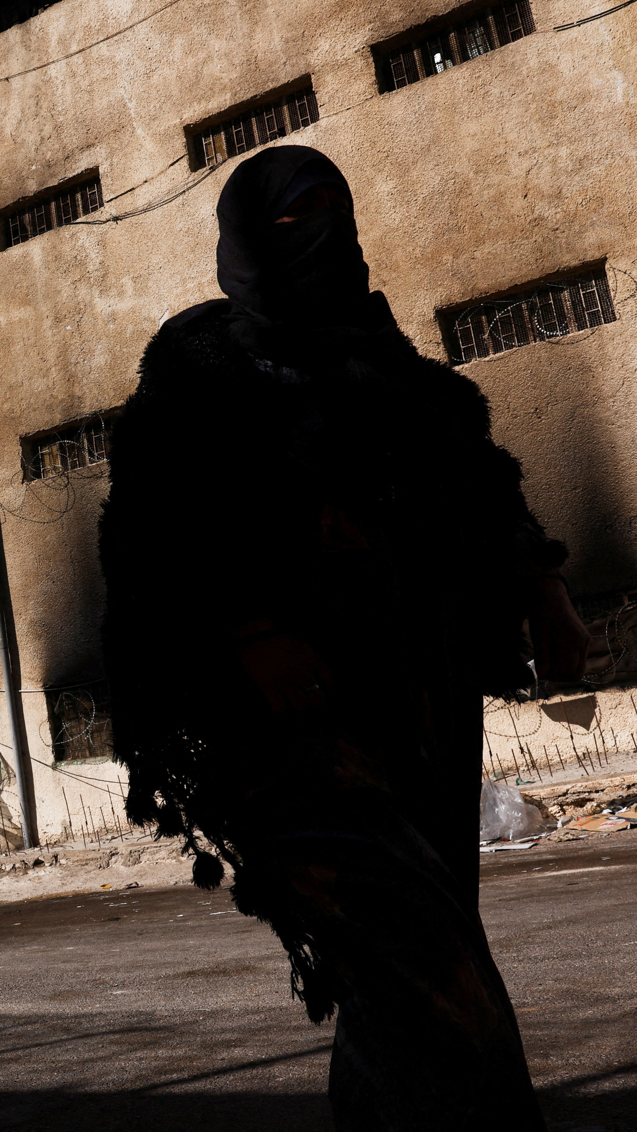 A woman walks past Sednaya prison in Sednaya, Syria, December 19, 2024 [Amr Alfiky/Reuters]