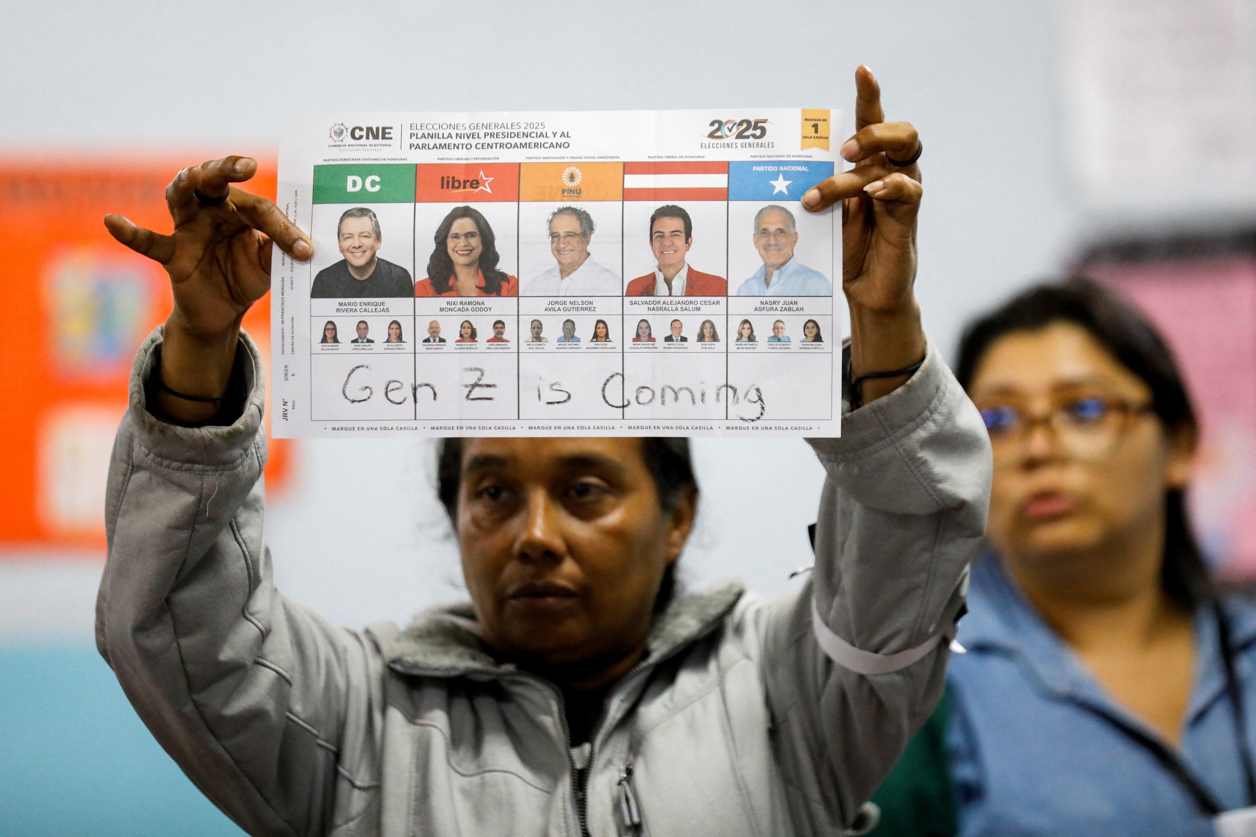 An election official shows a ballot paper with the words, "Gen Z is Coming" written on it, as the vote counting begins during the general election in Tegucigalpa, Honduras, November 30, 2025.