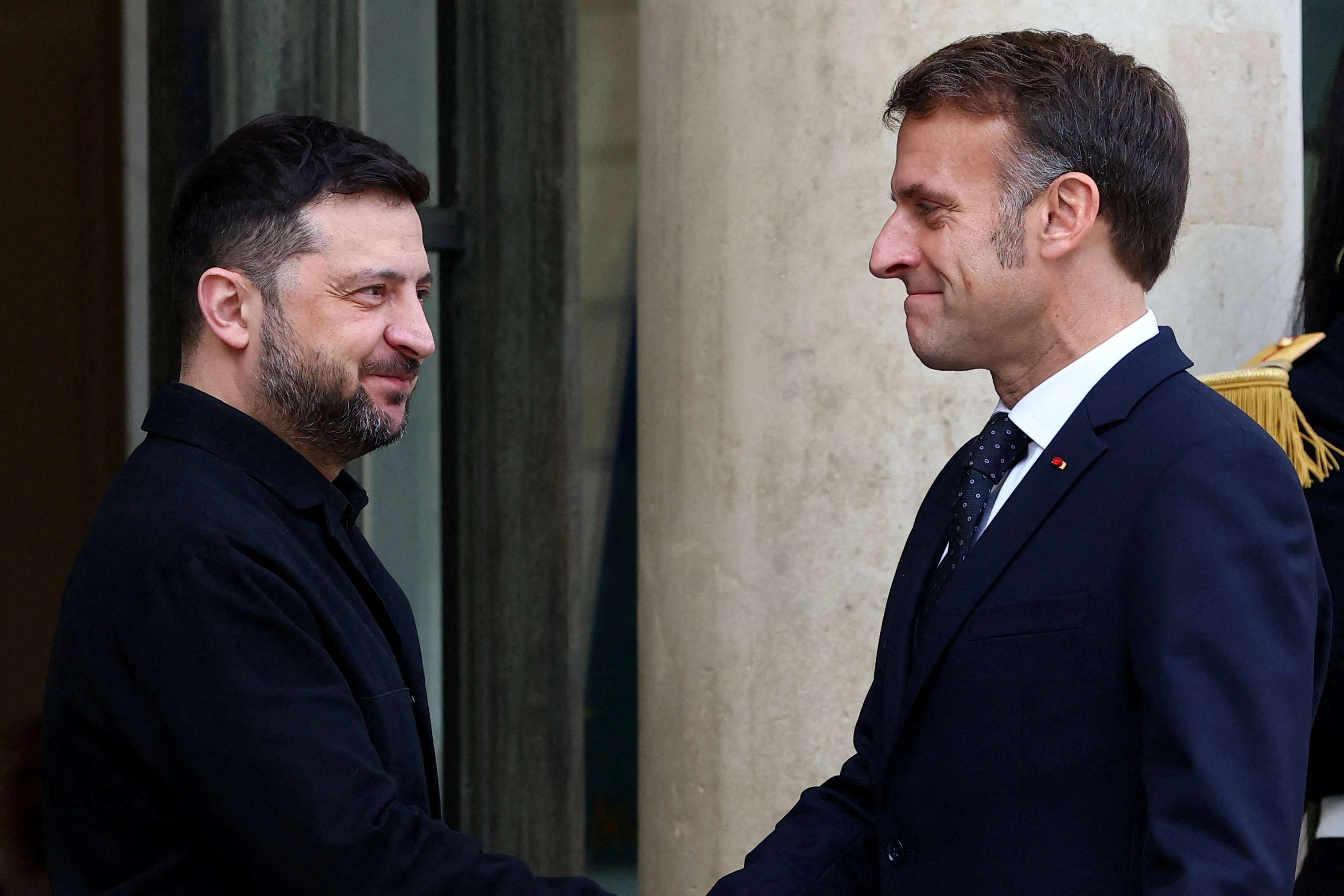 French President Emmanuel Macron welcomes Ukrainian President Volodymyr Zelenskiy as he arrives for a meeting at the Elysee Palace in Paris, France, December 1, 2025.