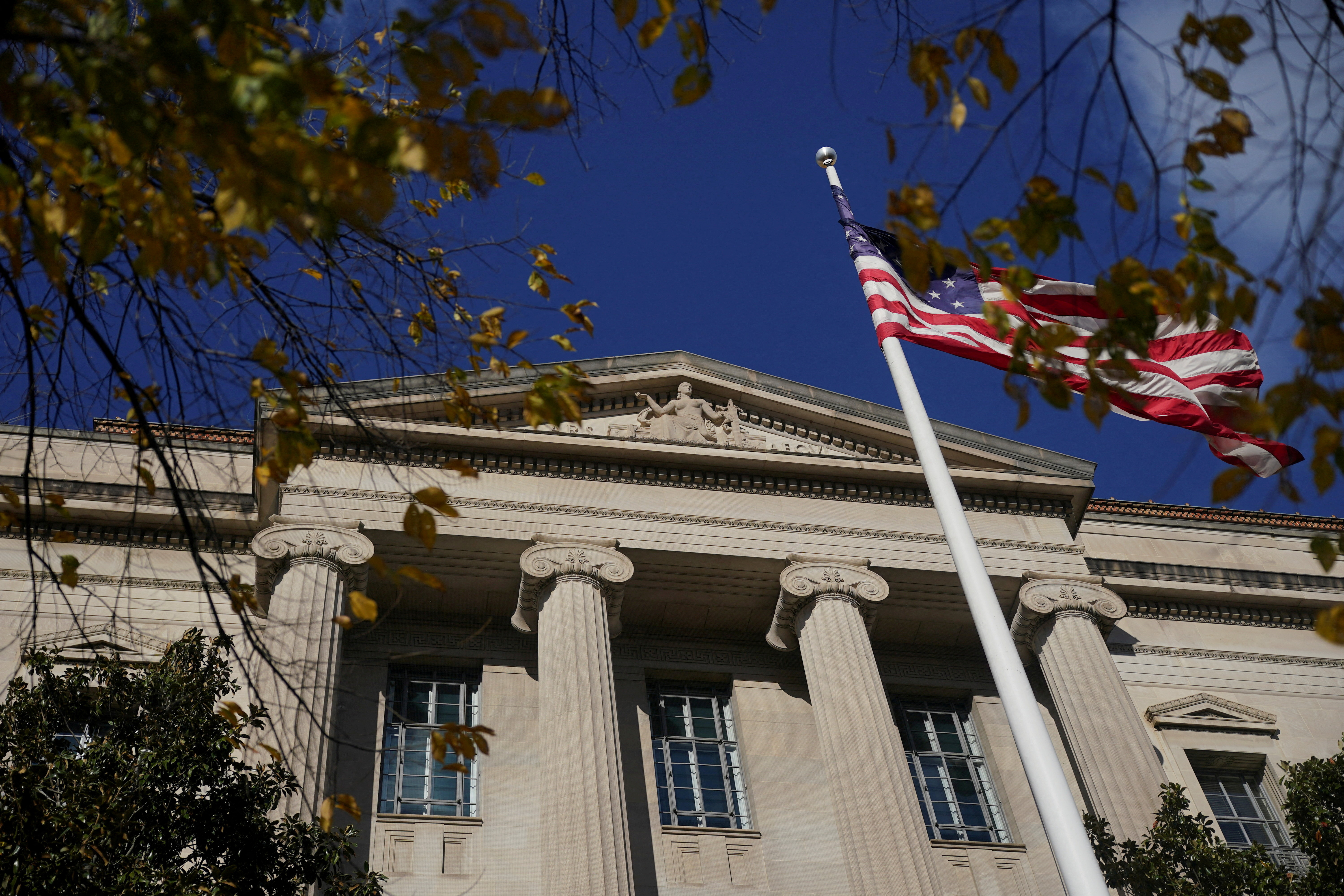 Exterior of the Department of Justice, with a flag pole in front.