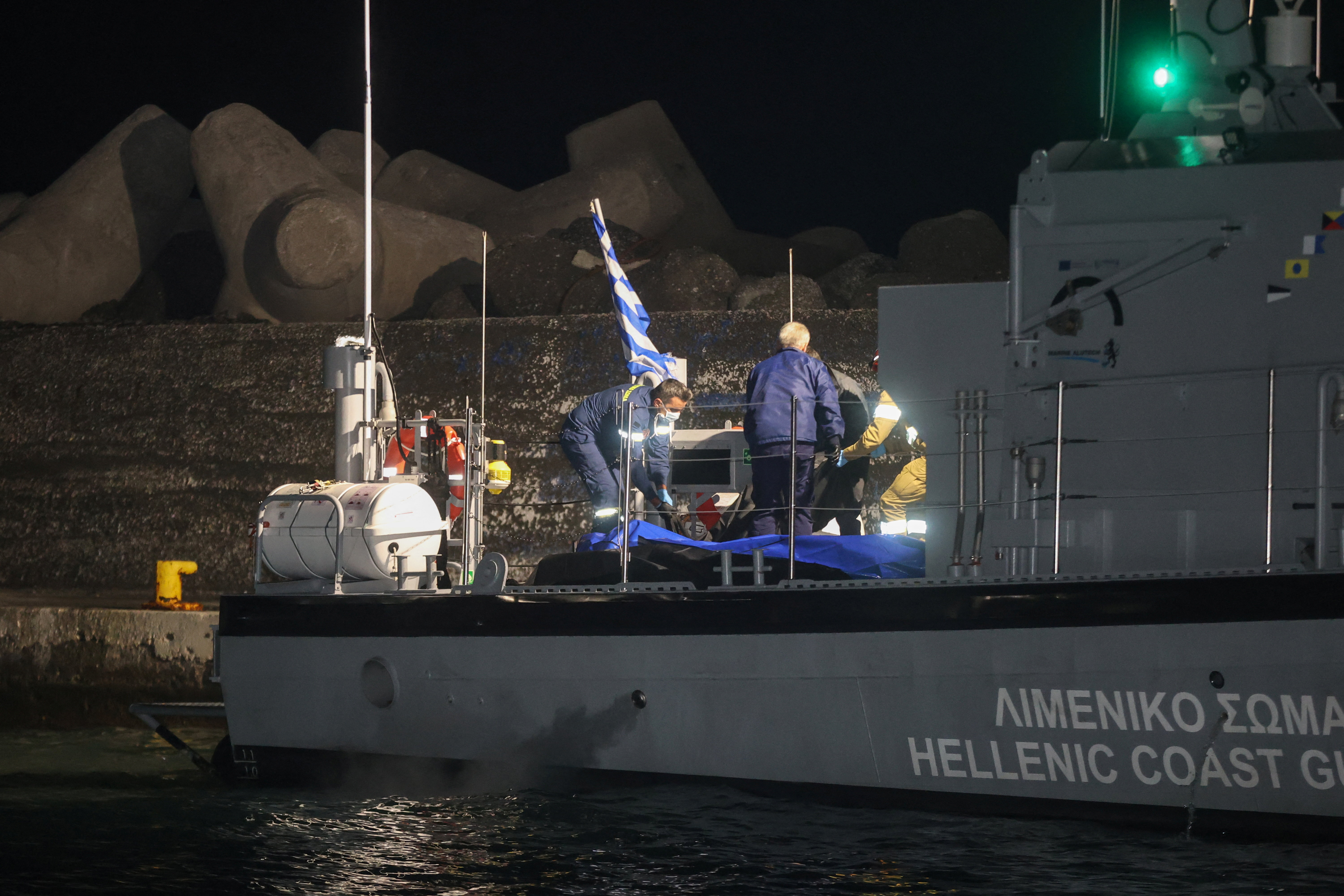 Coast guards carry bags with the bodies of drowned migrants, following a shipwreck off the tiny southern Greek island of Chrysi, in the port of Ierapetra, Crete island, Greece, December 6, 2025.