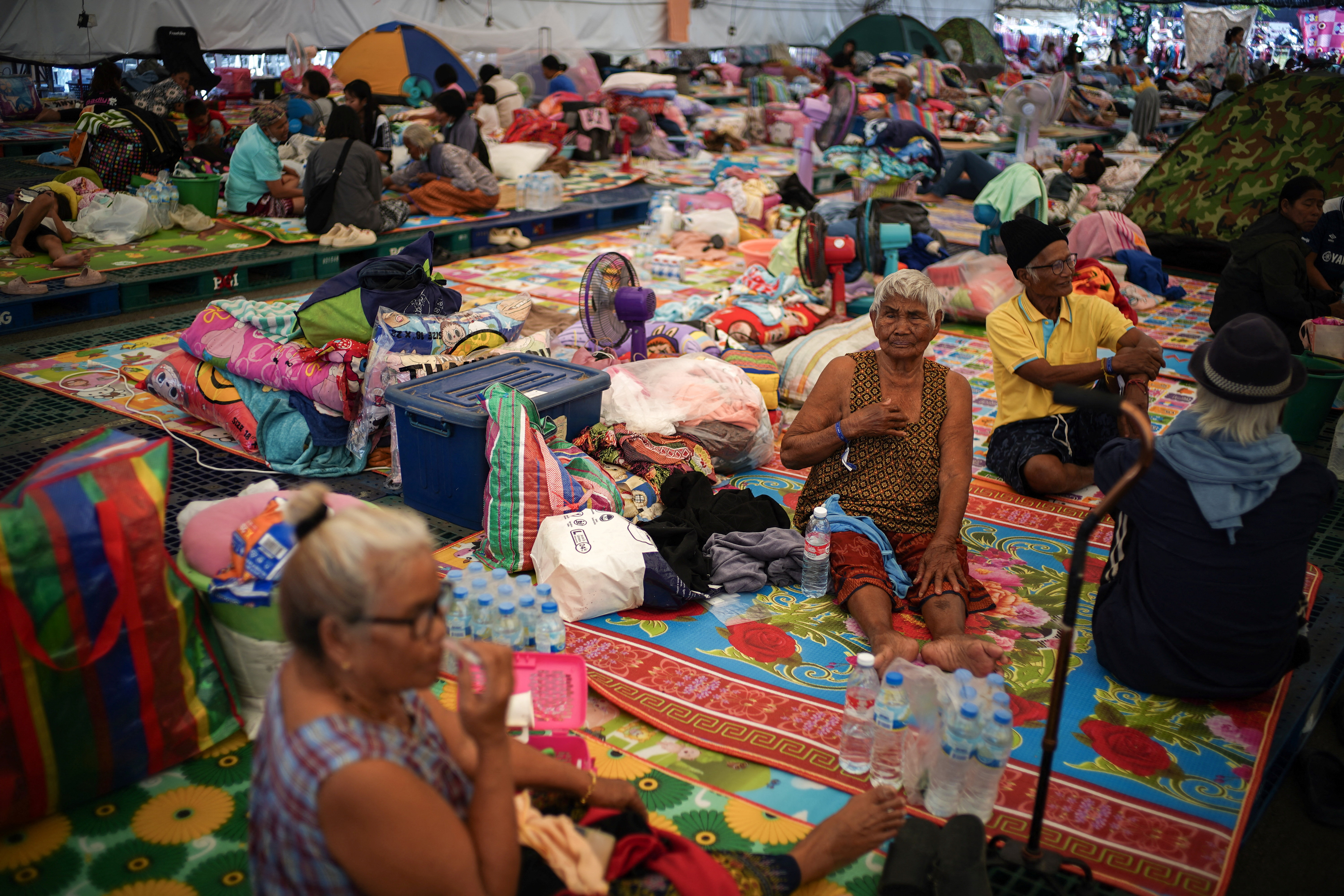 Displaced people gather inside a temporary shelter in Buriram province, Thailand