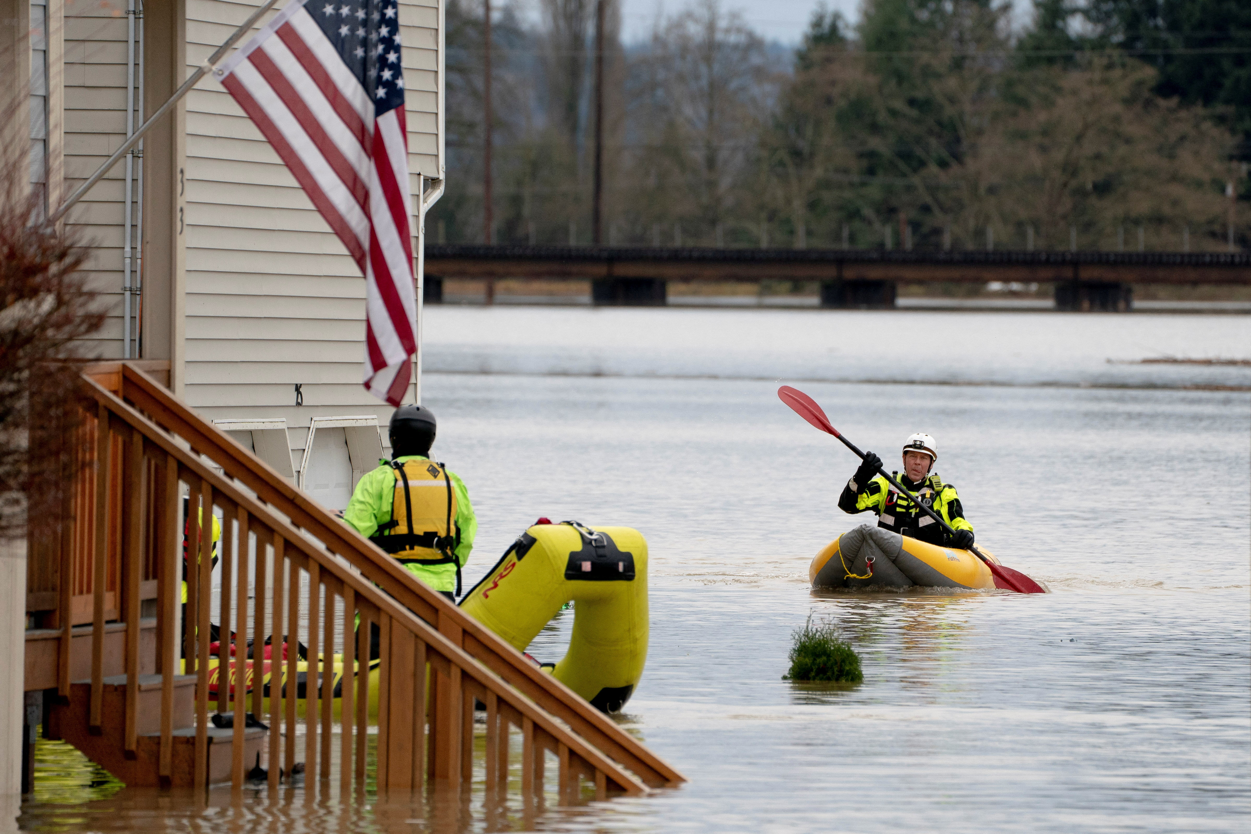 Rescue personnel prepare to evacuate residents from a home in an area flooded by the Snohomish River, as an atmospheric river brings rain and flooding to the Pacific Northwest, in Snohomish, Washington, U.S., December 11, 2025. REUTERS/David Ryder