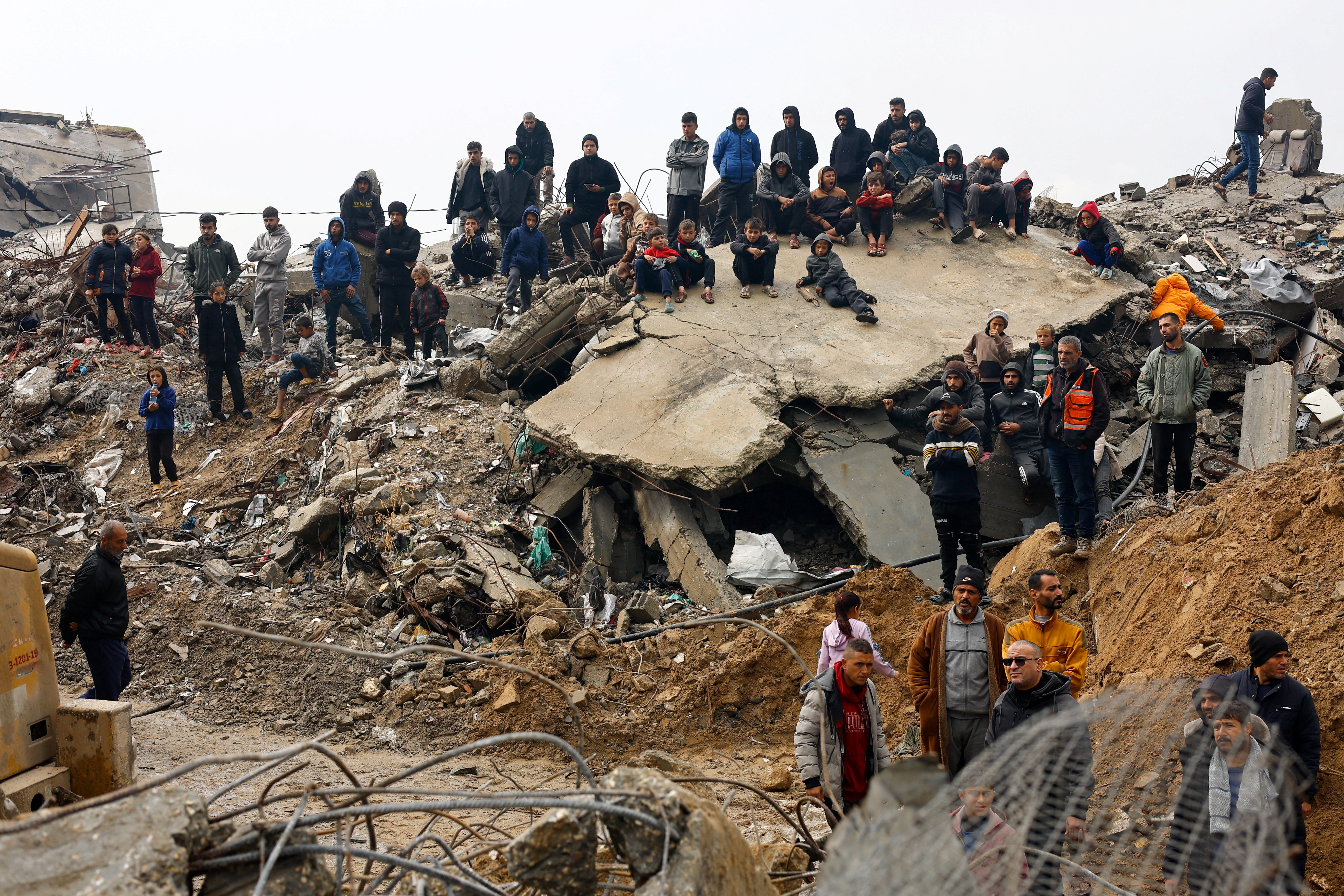 Palestinians gather on a pile of rubble in Beit Lahia, in the northern Gaza Strip