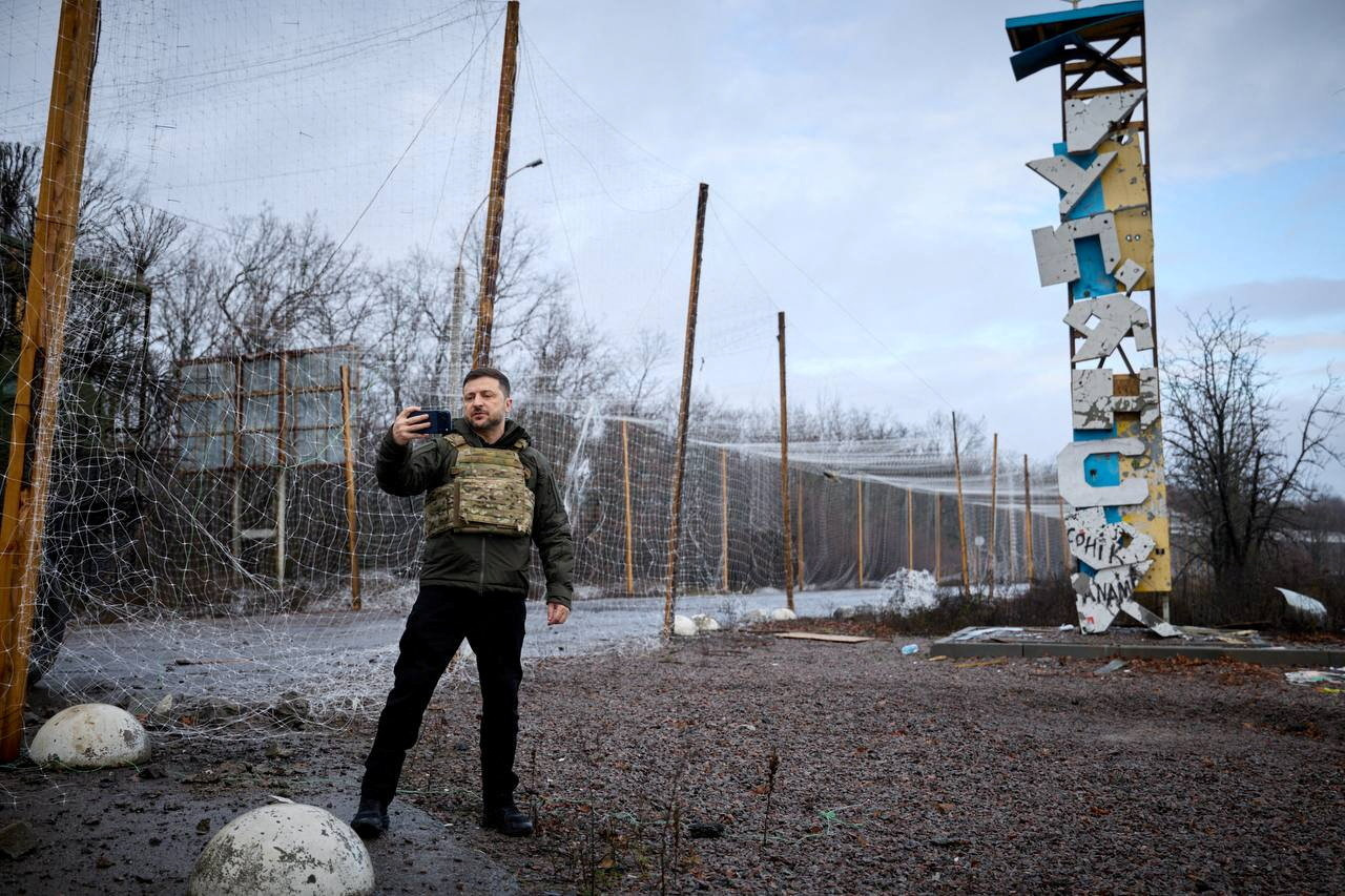 Ukraine's President Volodymyr Zelenskiy self-records a video in front of a sign that reads 'Kupiansk’, amid Russia's attack on Ukraine, in the frontline town of Kupiansk, Kharkiv region, Ukraine December 12, 2025. Ukrainian Presidential Press Service/Handout via REUTERS ATTENTION EDITORS - THIS IMAGE HAS BEEN SUPPLIED BY A THIRD PARTY. BEST QUALITY AVAILABLE