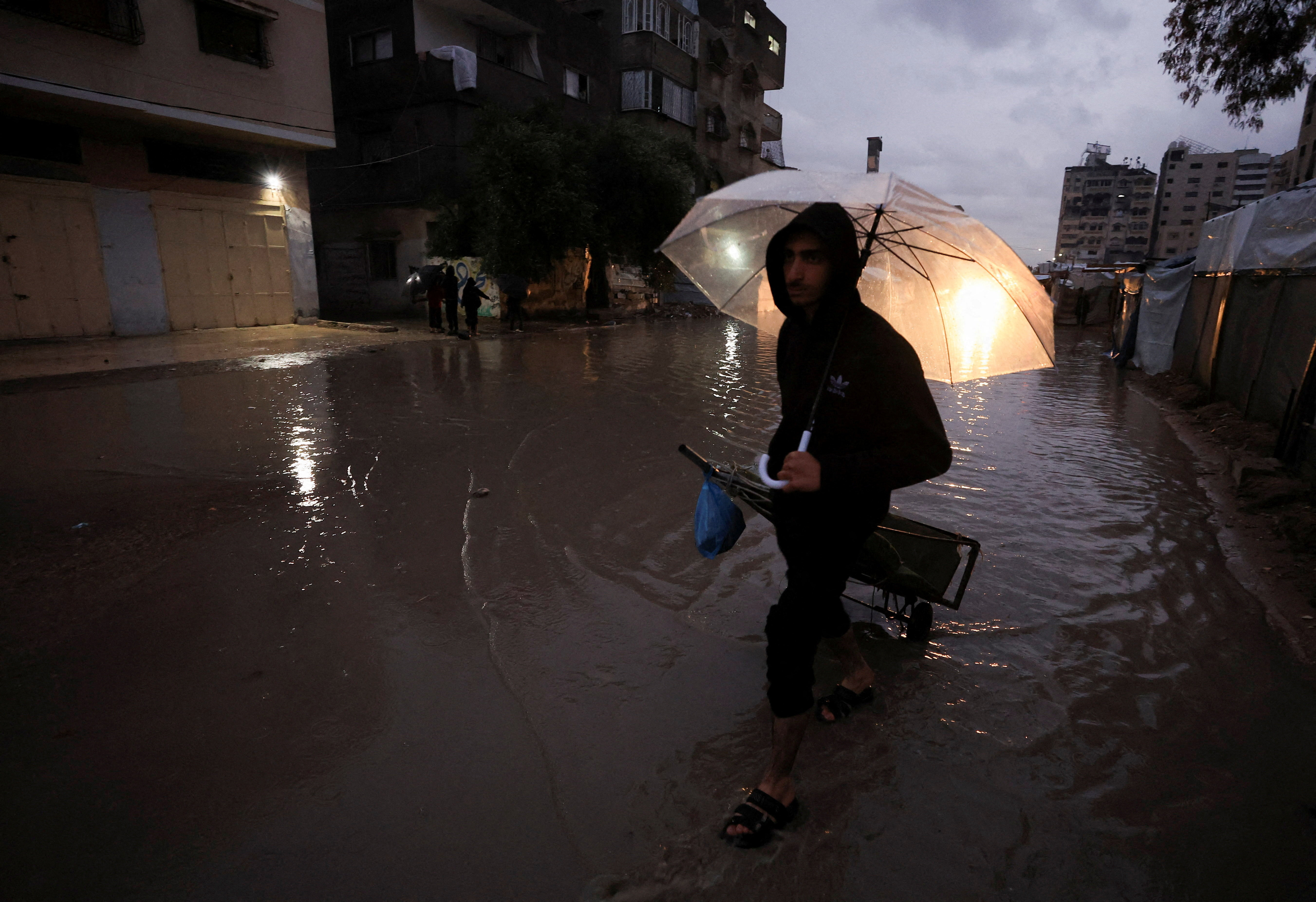 A Palestinian man walks in the rain in Gaza City