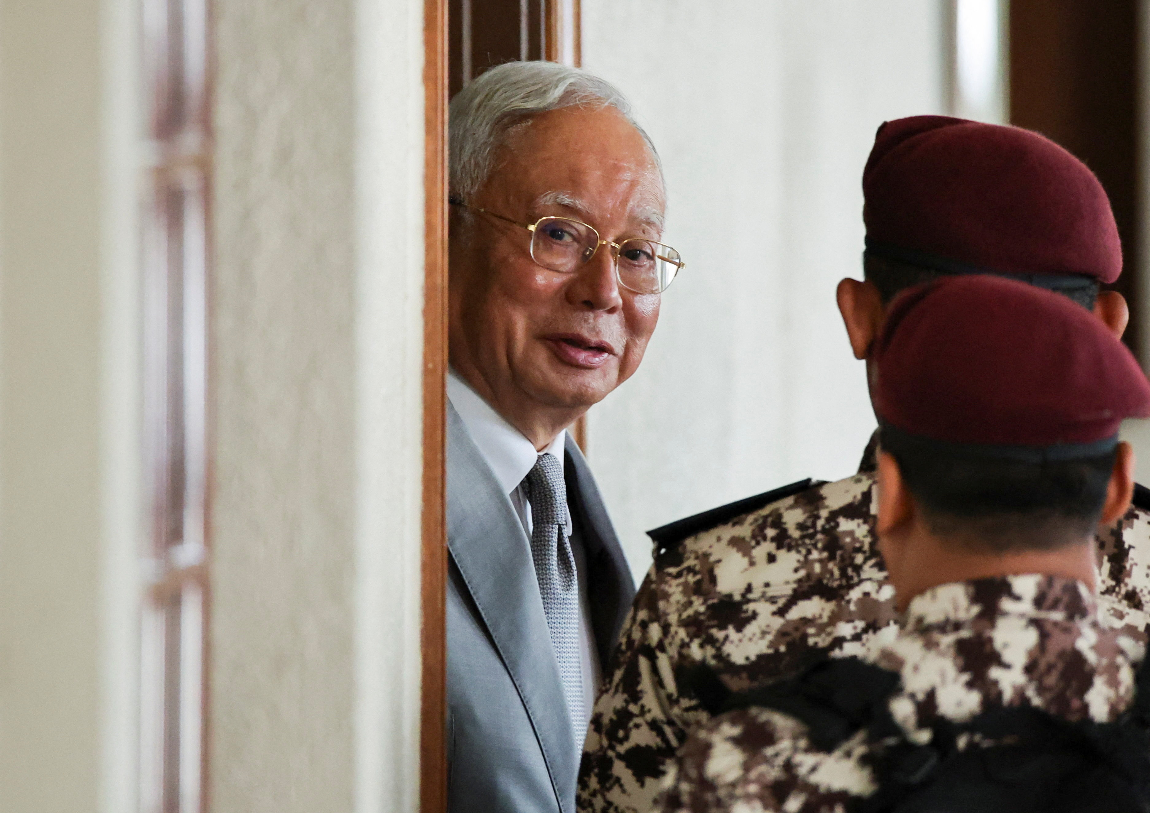 Malaysia's former Prime Minister Najib Razak is escorted by prison guards at court.