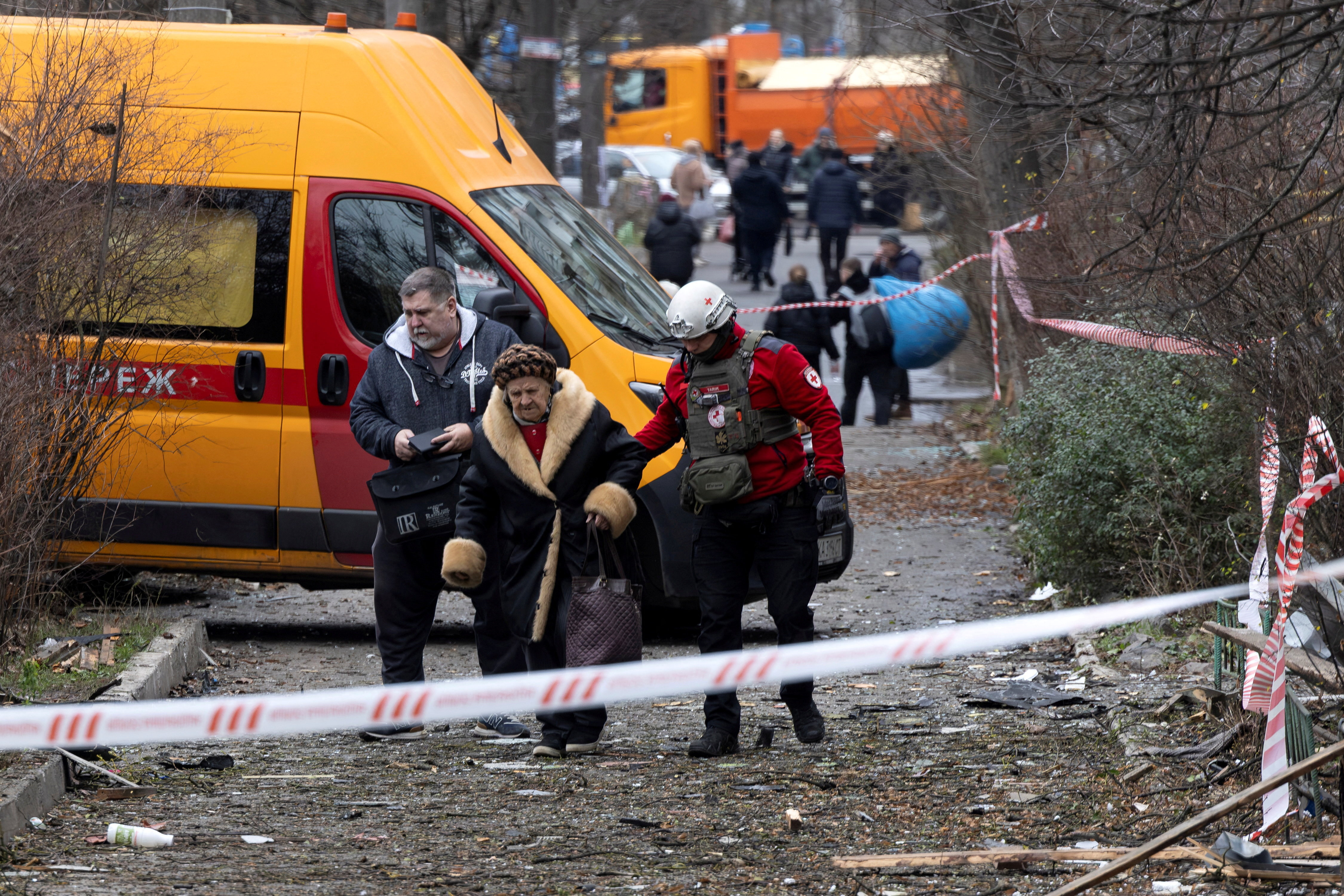 A medic assists a resident as she leaves her apartment building that was hit by a Russian drone, amid Russia's attack on Ukraine, in Kyiv, Ukraine December 23, 2025. REUTERS/Thomas Peter TPX IMAGES OF THE DAY