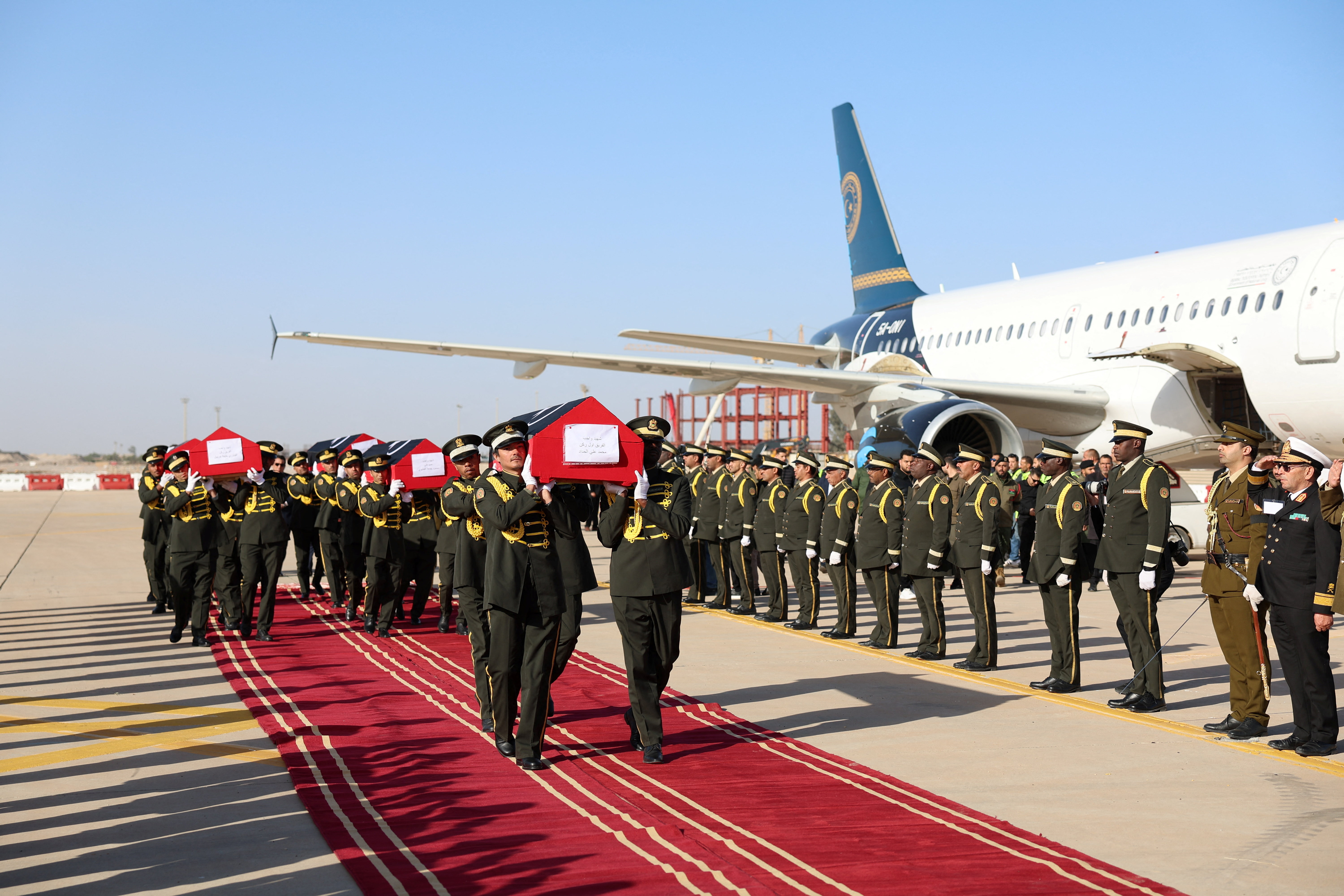 Soldiers carry the flag-draped caskets of Libya's army chief of staff Mohammed Ali Ahmed Al-Haddad and seven other officials who were killed when their plane crashed almost 30 minutes after takeoff from Ankara on its flight to Tripoli, following the arrival of their bodies in Tripoli, Libya, December 27, 2025. Libyan Government Platform/Handout via REUTERS ATTENTION EDITORS - THIS IMAGE HAS BEEN SUPPLIED BY A THIRD PARTY.