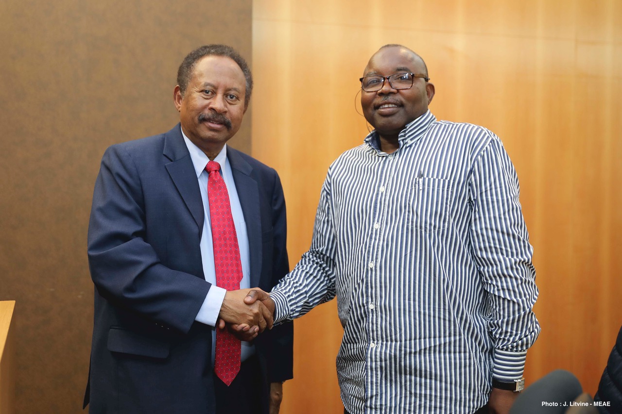 Abdallah Hamdok on the left in a suit and Abdel Wahid Nur on the right in a striped shirt