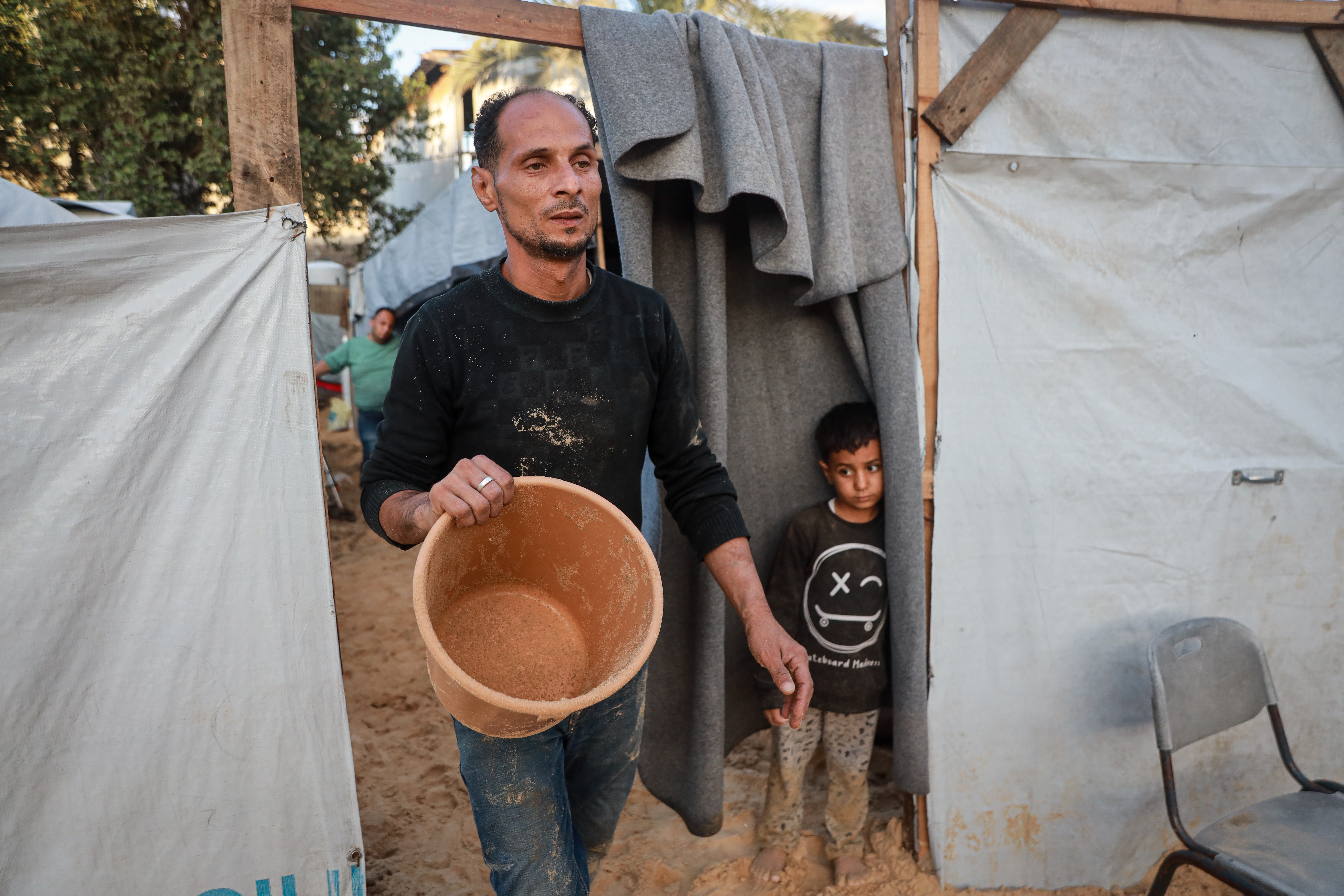 A man holds an empty bucket