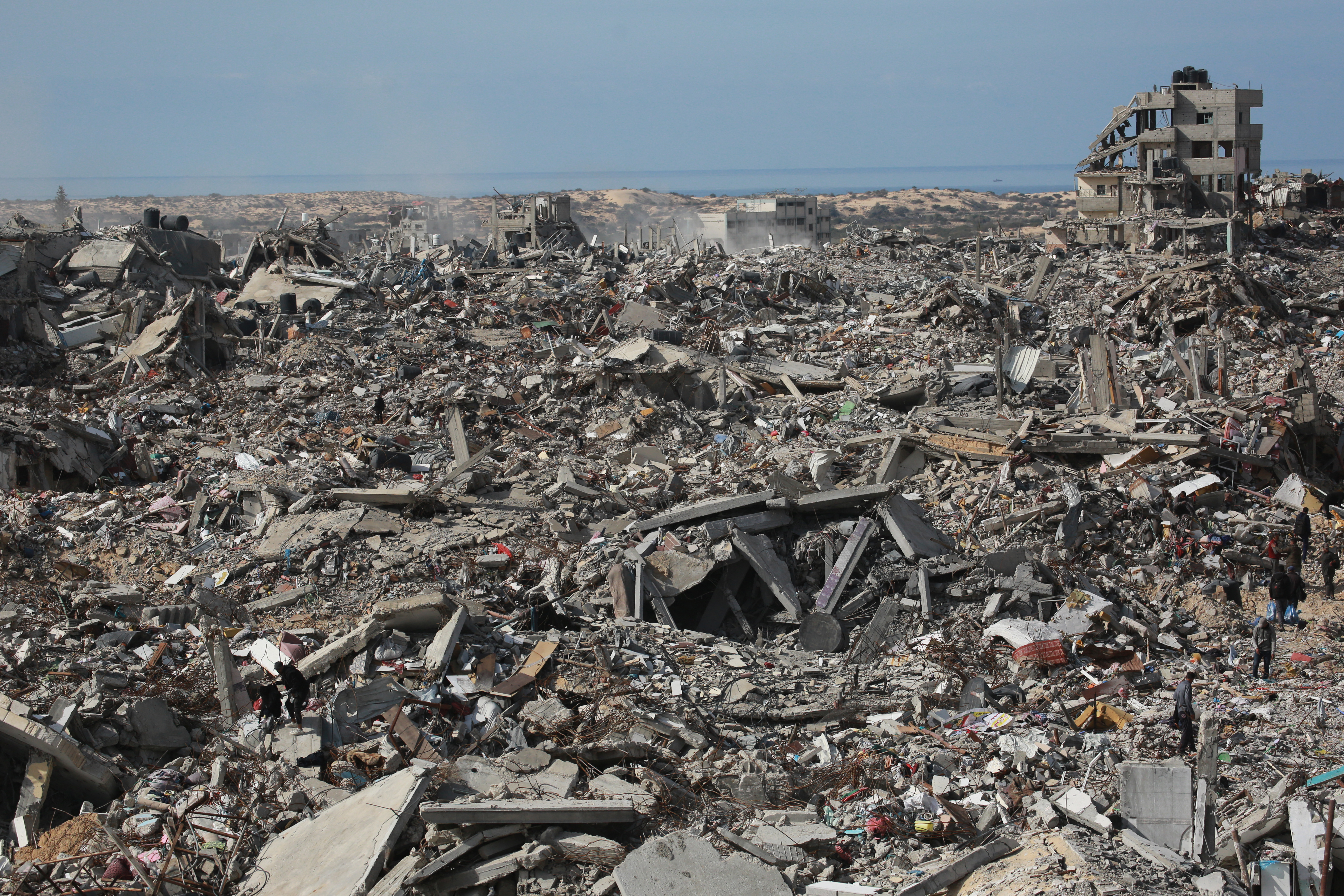 Displaced Palestinians walk amid the devastation in Gaza.