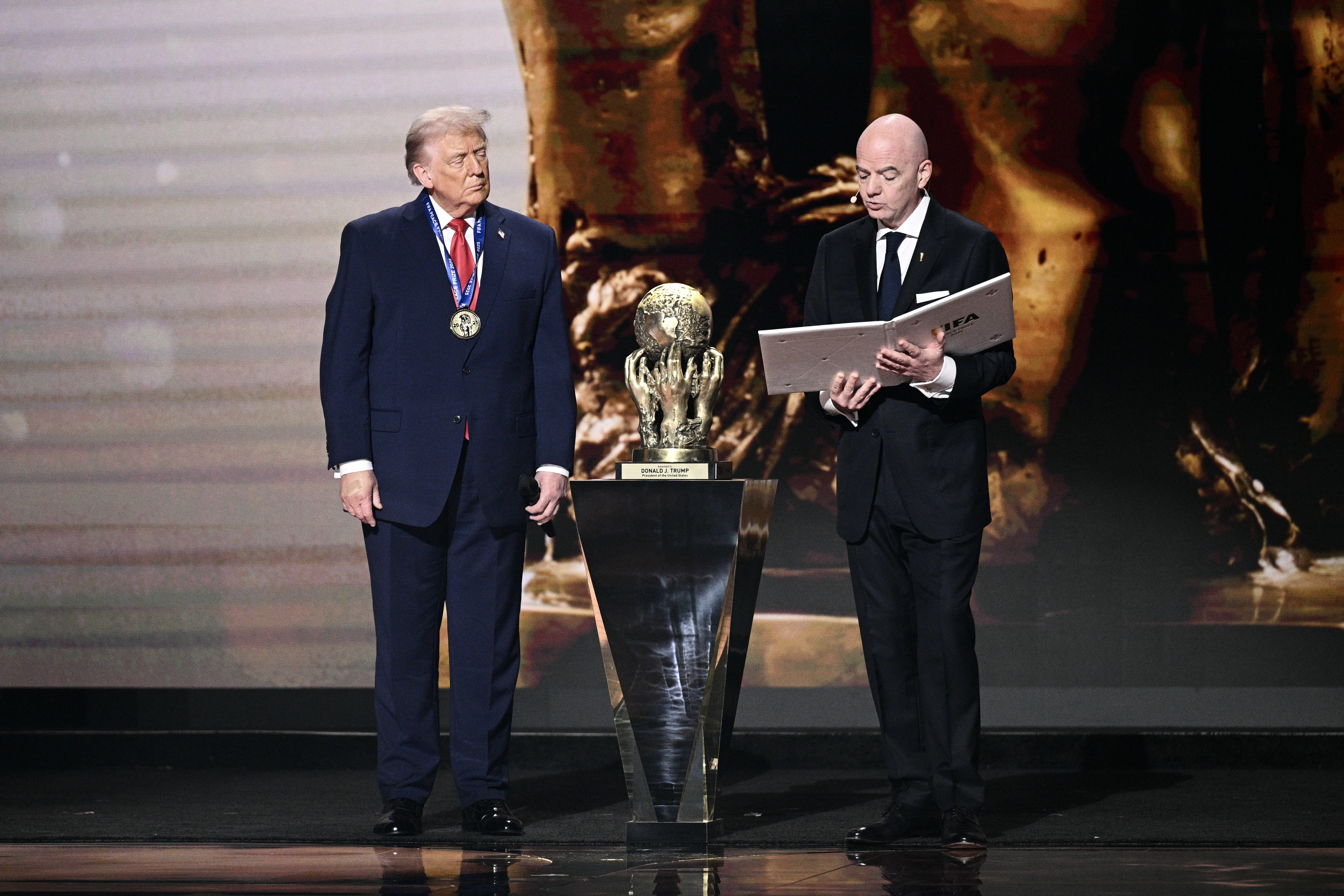 US President Donald Trump looks on as he receives the FIFA Peace Prize from FIFA President Gianni Infantino during the draw for the 2026 FIFA Football World Cup taking place in the US, Canada and Mexico, at the Kennedy Center, in Washington, DC, on December 5, 2025.