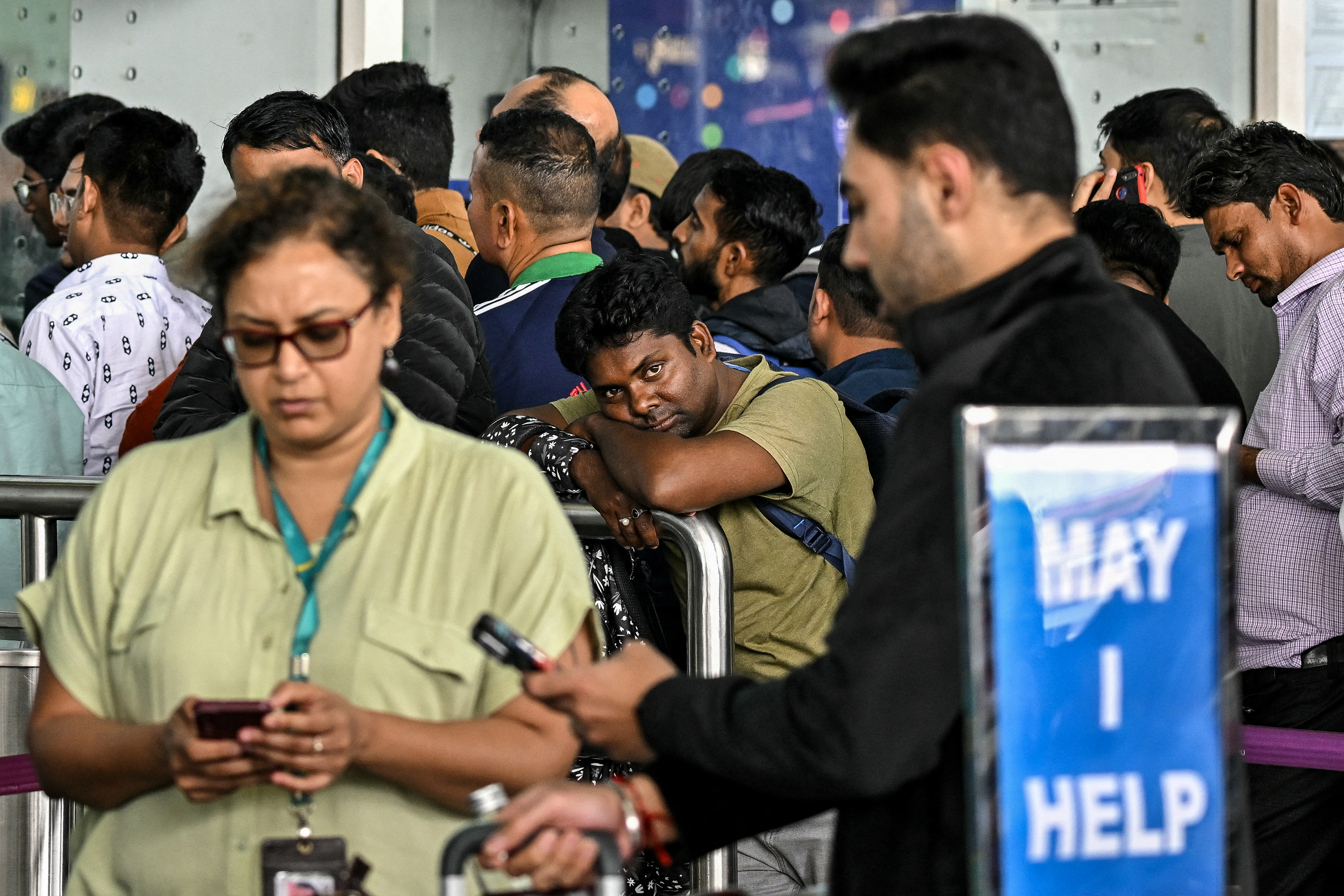 Passengers wait outside the IndiGo Airlines kiosk at the Kempegowda International Airport in Bengaluru