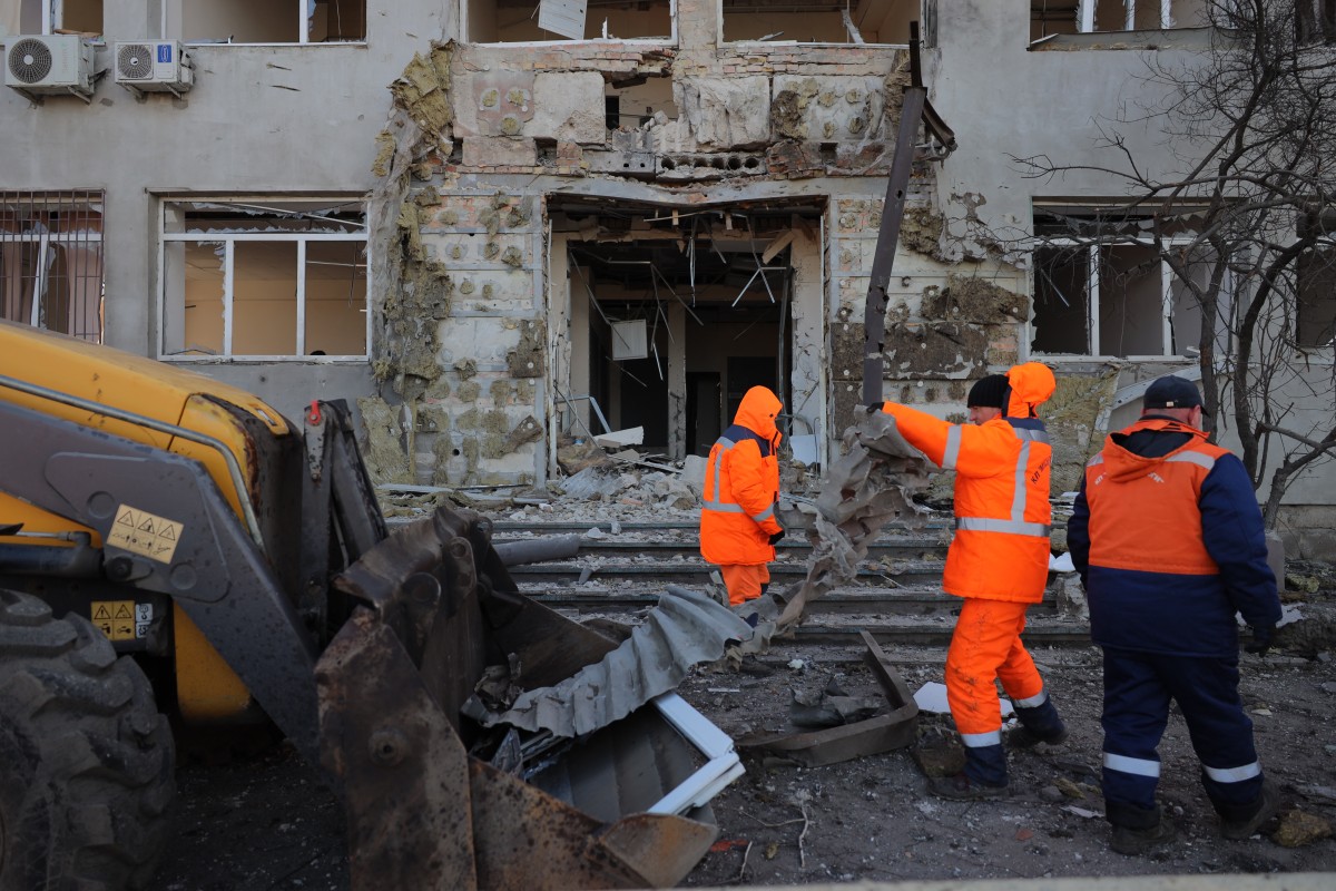 Communal workers clean debris in the courtyard of damaged buildings following an air attack in Odesa on December 13, 2025, amid the Russian invasion in Ukraine. (Photo by Oleksandr GIMANOV / AFP)