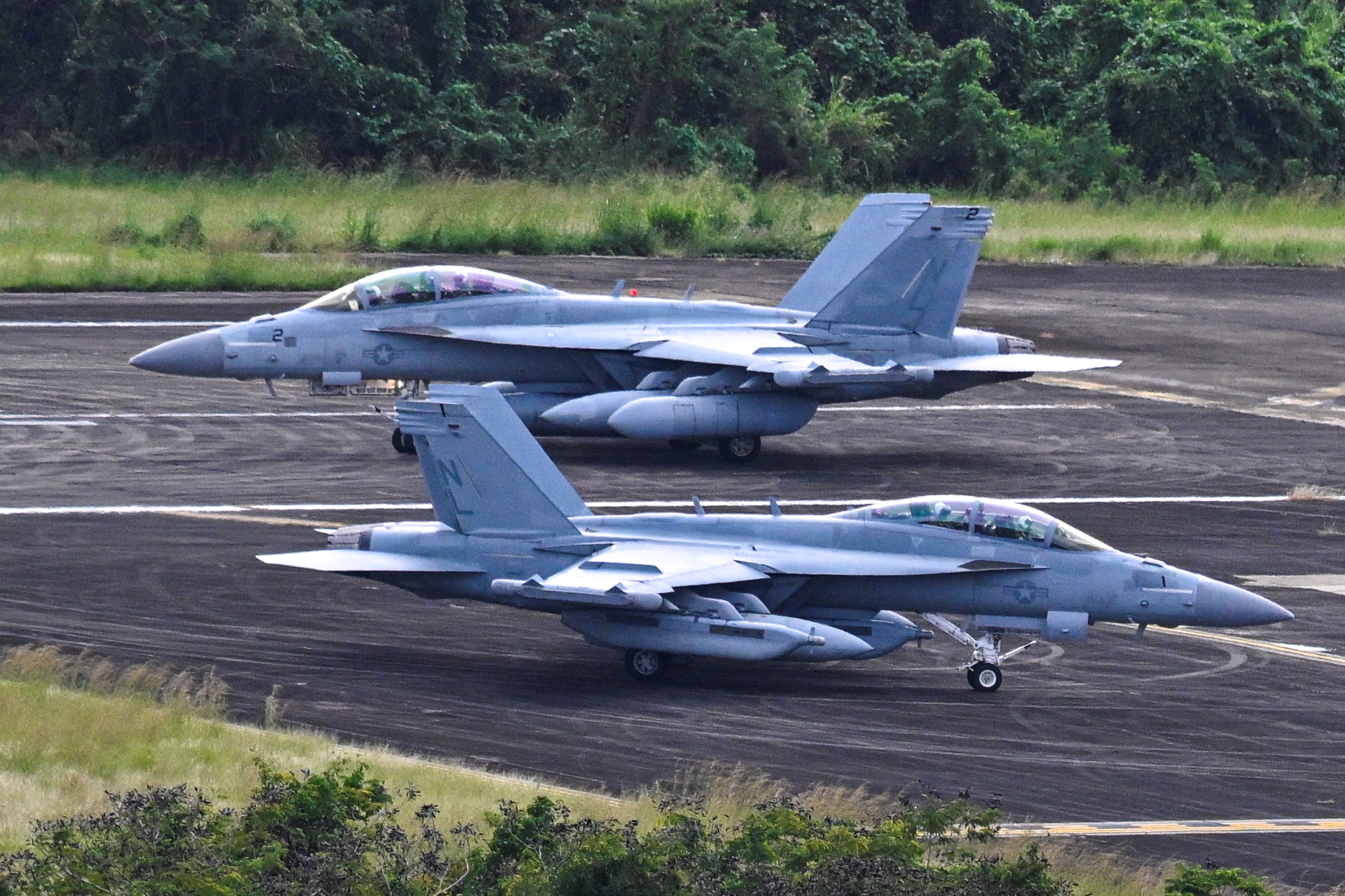 US Navy Boeing EA-18G Growlers taxi at José Aponte de la Torre Airport, formerly Roosevelt Roads Naval Station, on December 17, 2025 in Ceiba, Puerto Rico. Aircraft movements and coordinated exercises were observed throughout the day as part of heightened regional military readiness linked to ongoing operations at US military bases and maritime security efforts in the Caribbean. President Donald Trump administration is conducting a military campaign in the Caribbean and eastern Pacific, deploying naval and air forces for what it calls an anti-drugs offensive. (Photo by Miguel J. Rodriguez Carrillo / AFP)